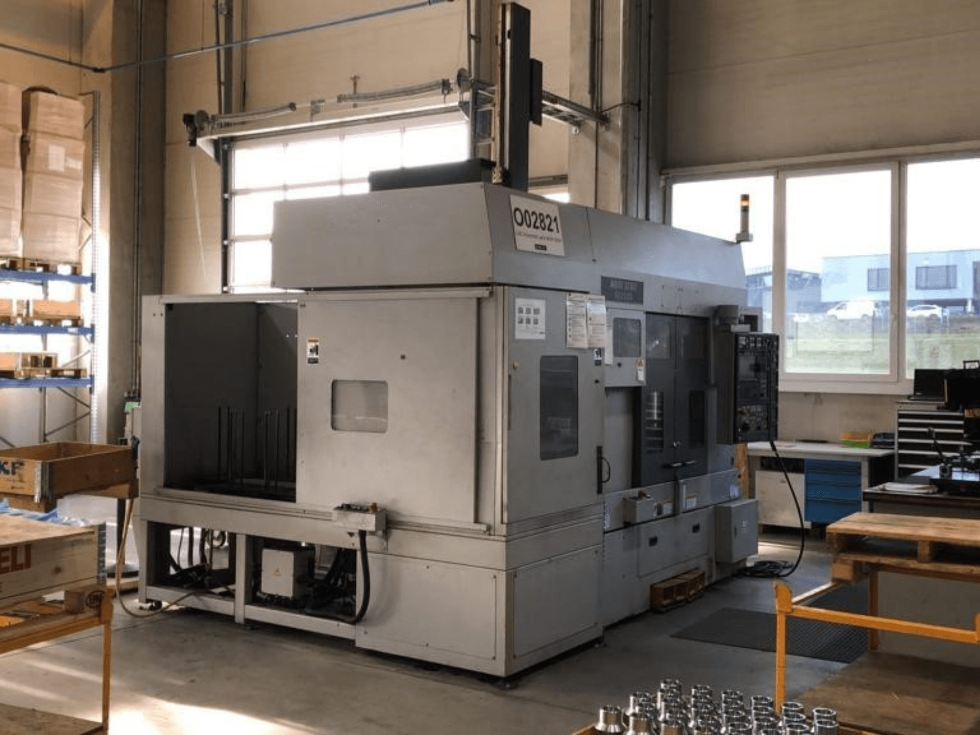 Torneiro multifuso MORI SEIKI RL2500 numa oficina, mostrando a vista frontal e a área de produção com ferramentas.