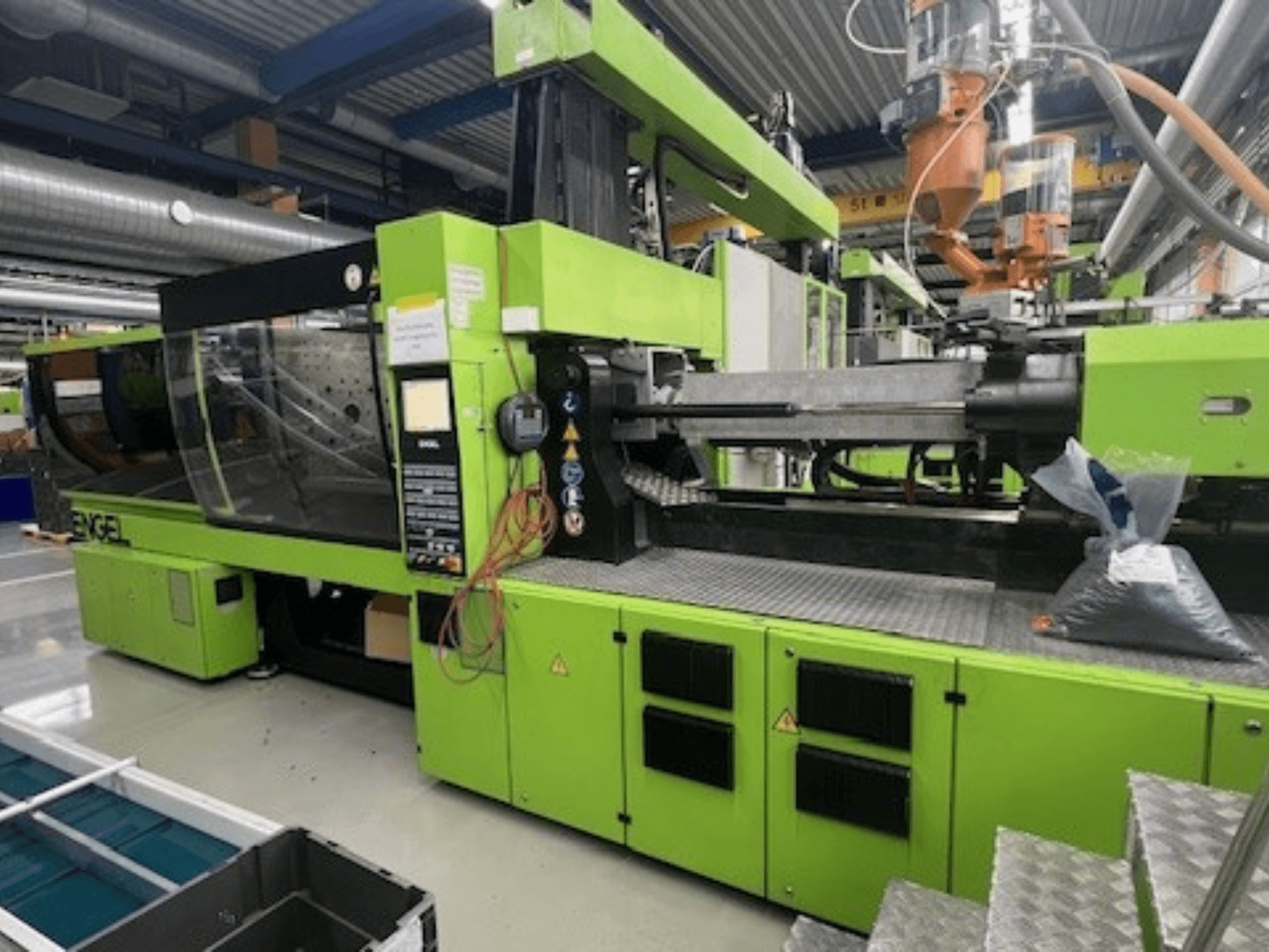 Máquina de moldagem por injeção hidráulica Engel Victory VC1800/300 P, exterior verde, vista frontal com painel de controlo e espaço de trabalho visíveis.