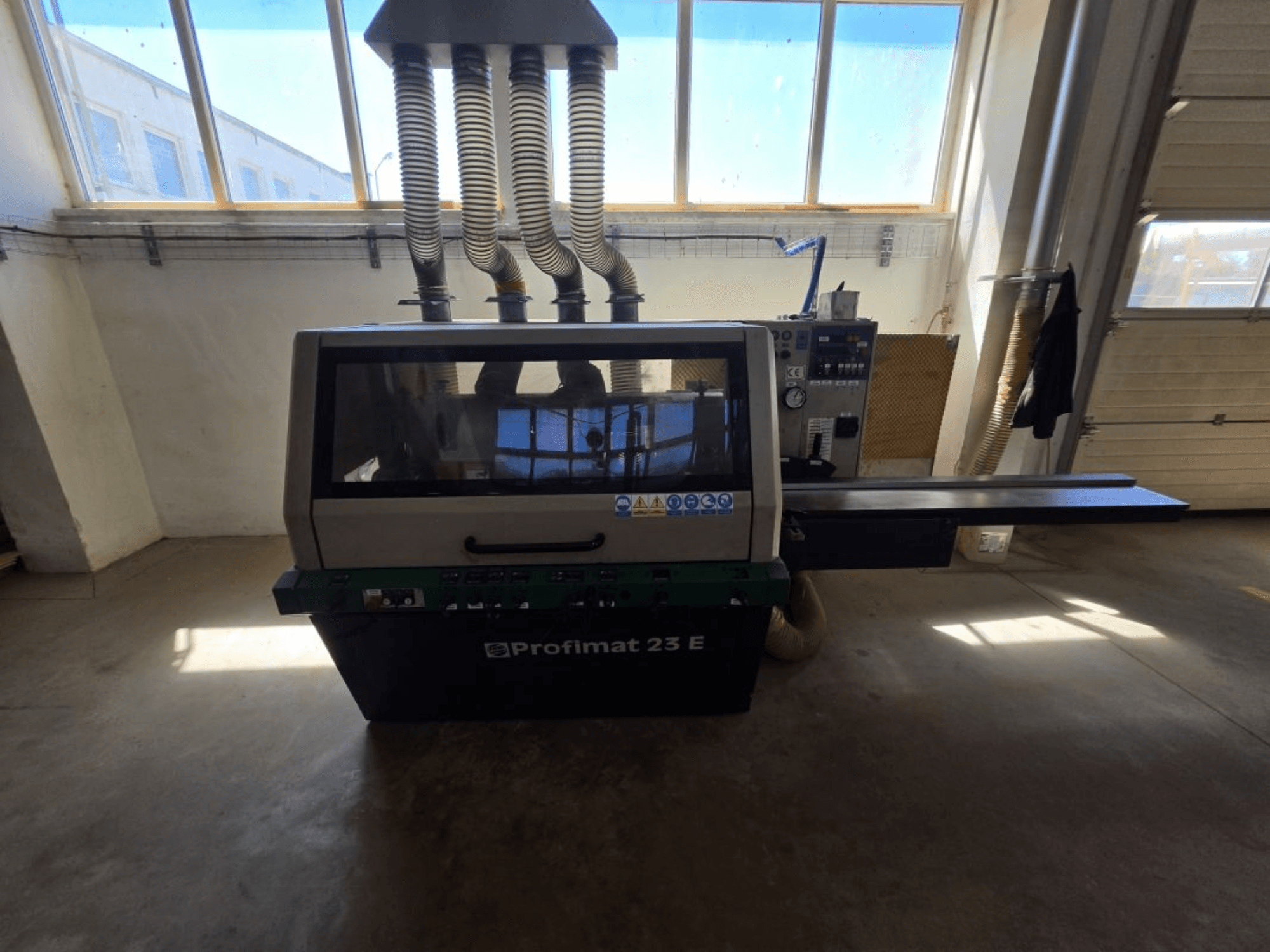 Plaina para madeira WEINIG DIMTER PROFIMAT 23 E, vista frontal, com painel de controlo e mangueiras de extração de pó visíveis, numa oficina.