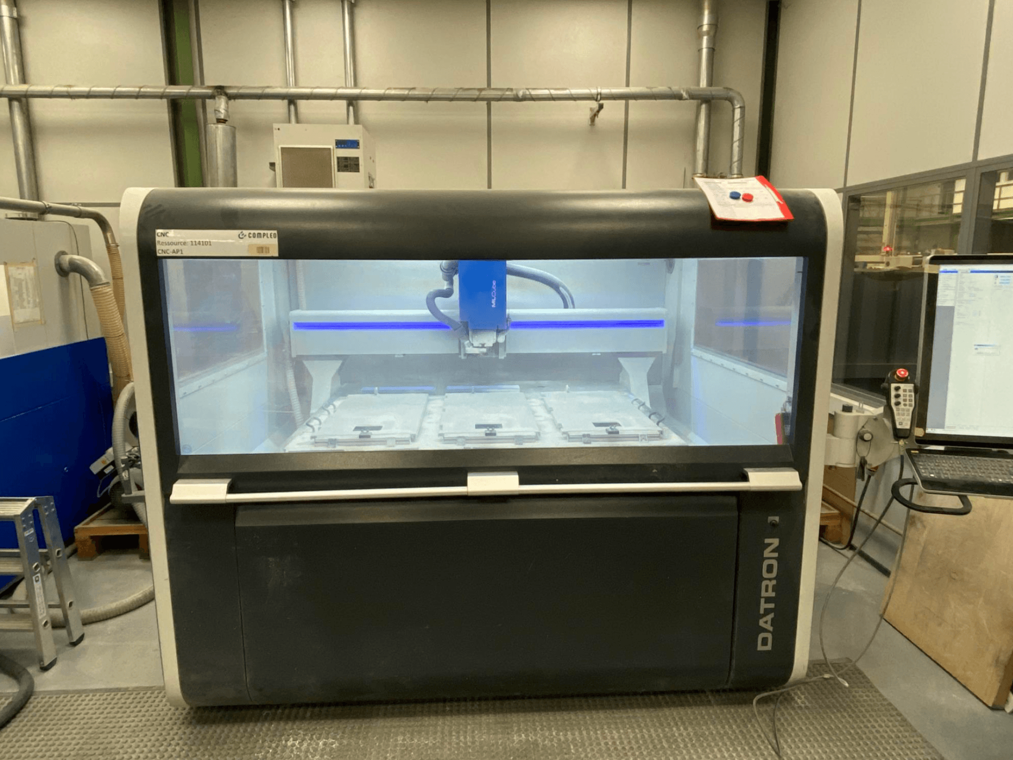 Centro de maquinação vertical Datron MLCube B, vista frontal, mostrando o interior da máquina e o painel de controlo.