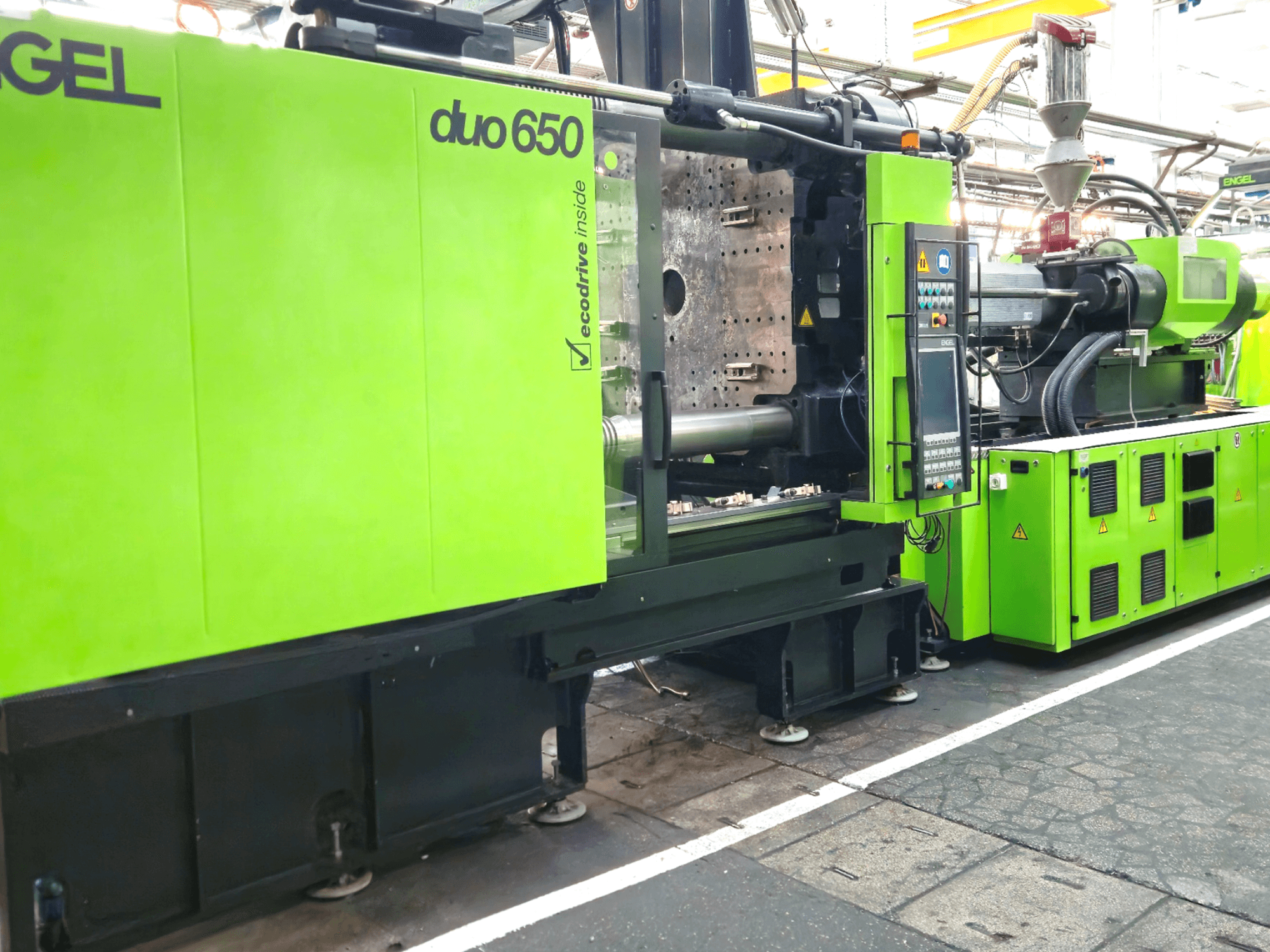 Máquina de moldagem por injeção ENGEL duo 650, vista frontal, cor verde brilhante, com painel de controlo e tremonha visíveis.