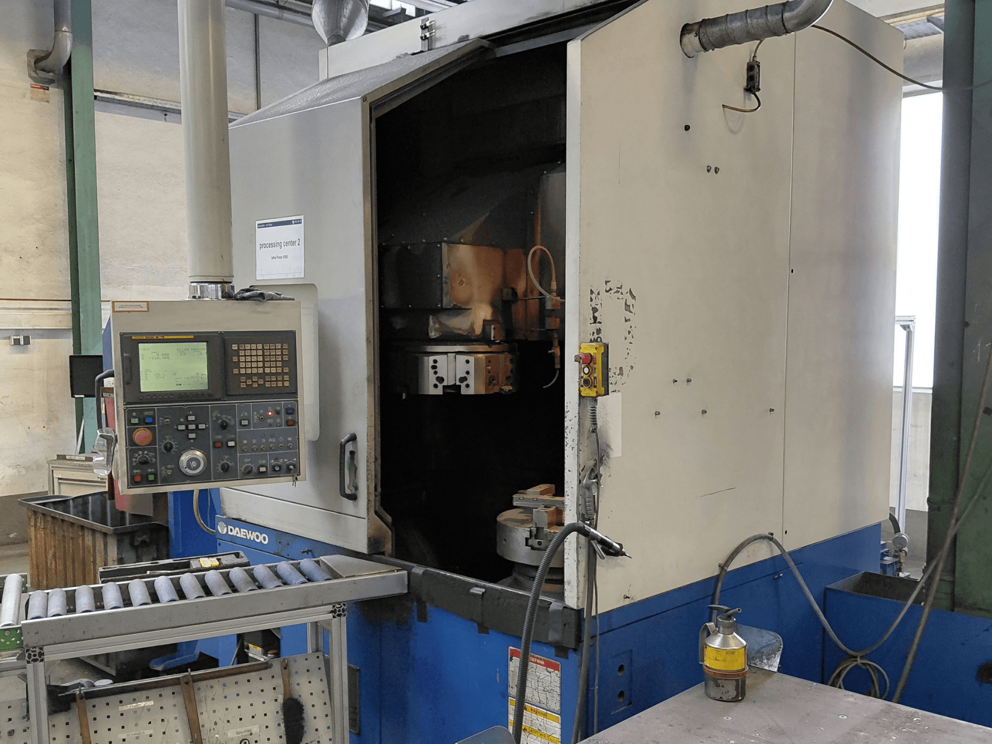 Torneiro vertical Daewoo Puma V550, vista frontal mostrando o painel de controlo, o fuso e a ligação do líquido de refrigeração.