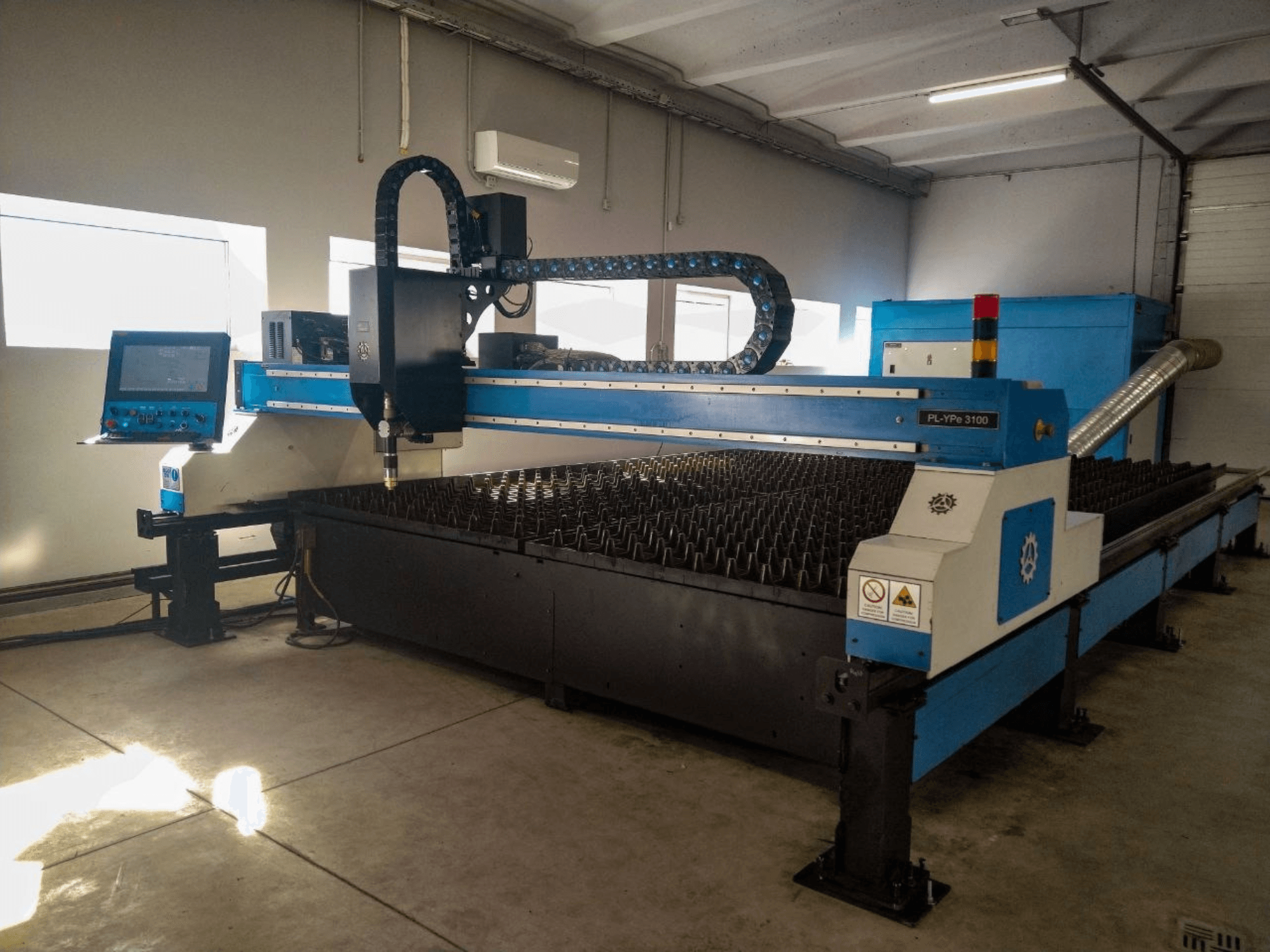 Máquina de corte plasma INANMAK MEKOR PL-YPe 3100, vista frontal, com painel de controlo e mesa de corte com espigões metálicos elevados.