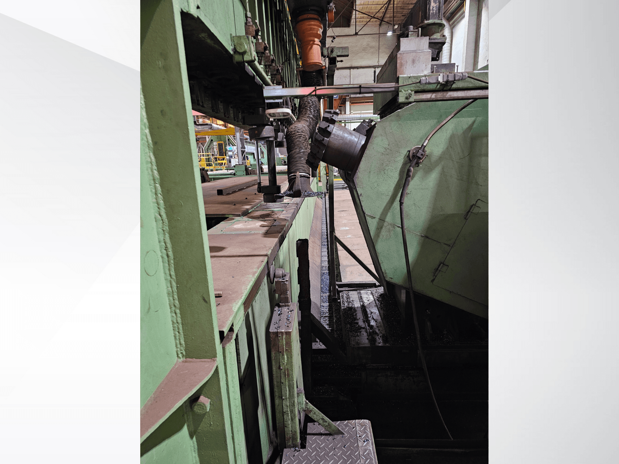 Maquinaria industrial verde com vista lateral de uma tremonha e mecanismo de alimentação, apresentando componentes metálicos e uma plataforma.