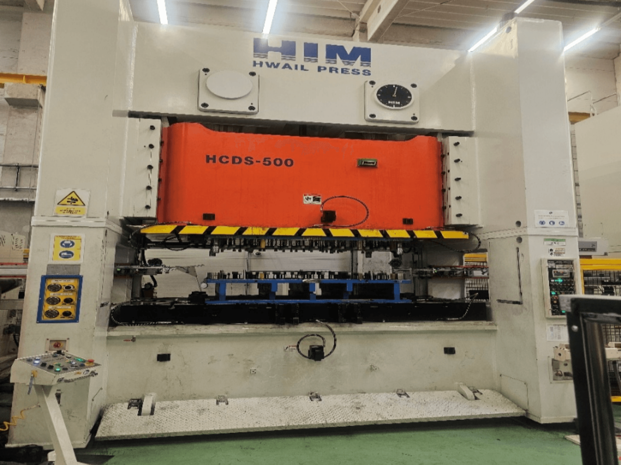Prensa mecânica de estampagem HIM HWAIl PRESS HCDS-500 vista de frente, com uma placa de prensagem laranja e um painel de controlo.