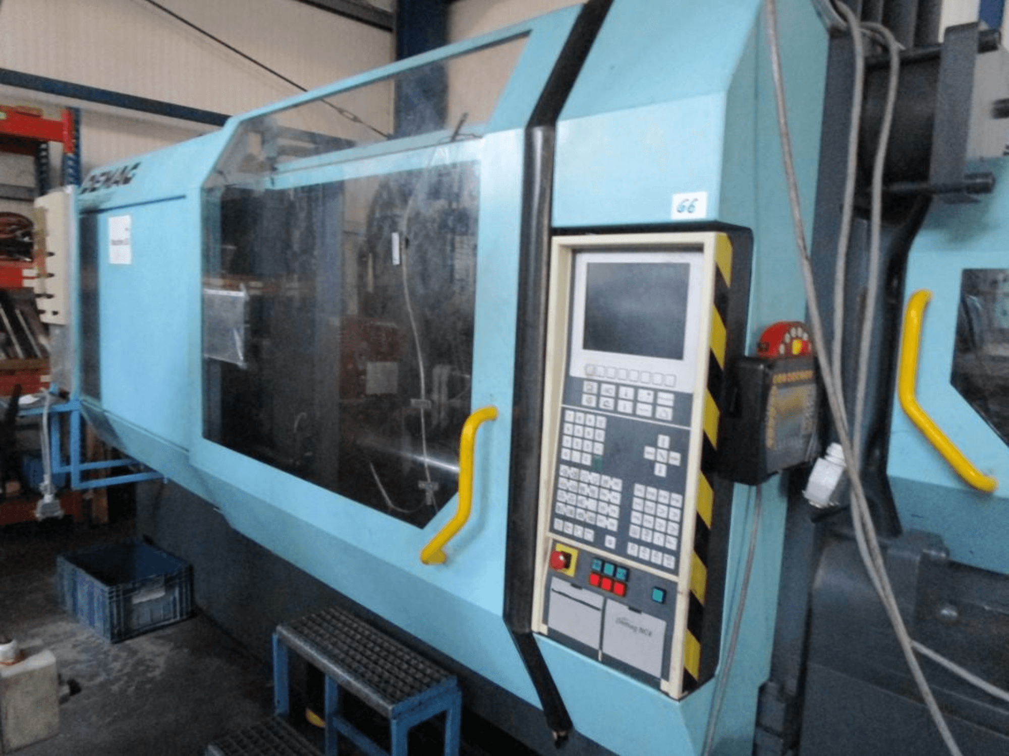 Máquina de moldagem por injeção hidráulica Demag Erdotech 500-3300, vista frontal, com painel de controlo e caixa de segurança transparente.