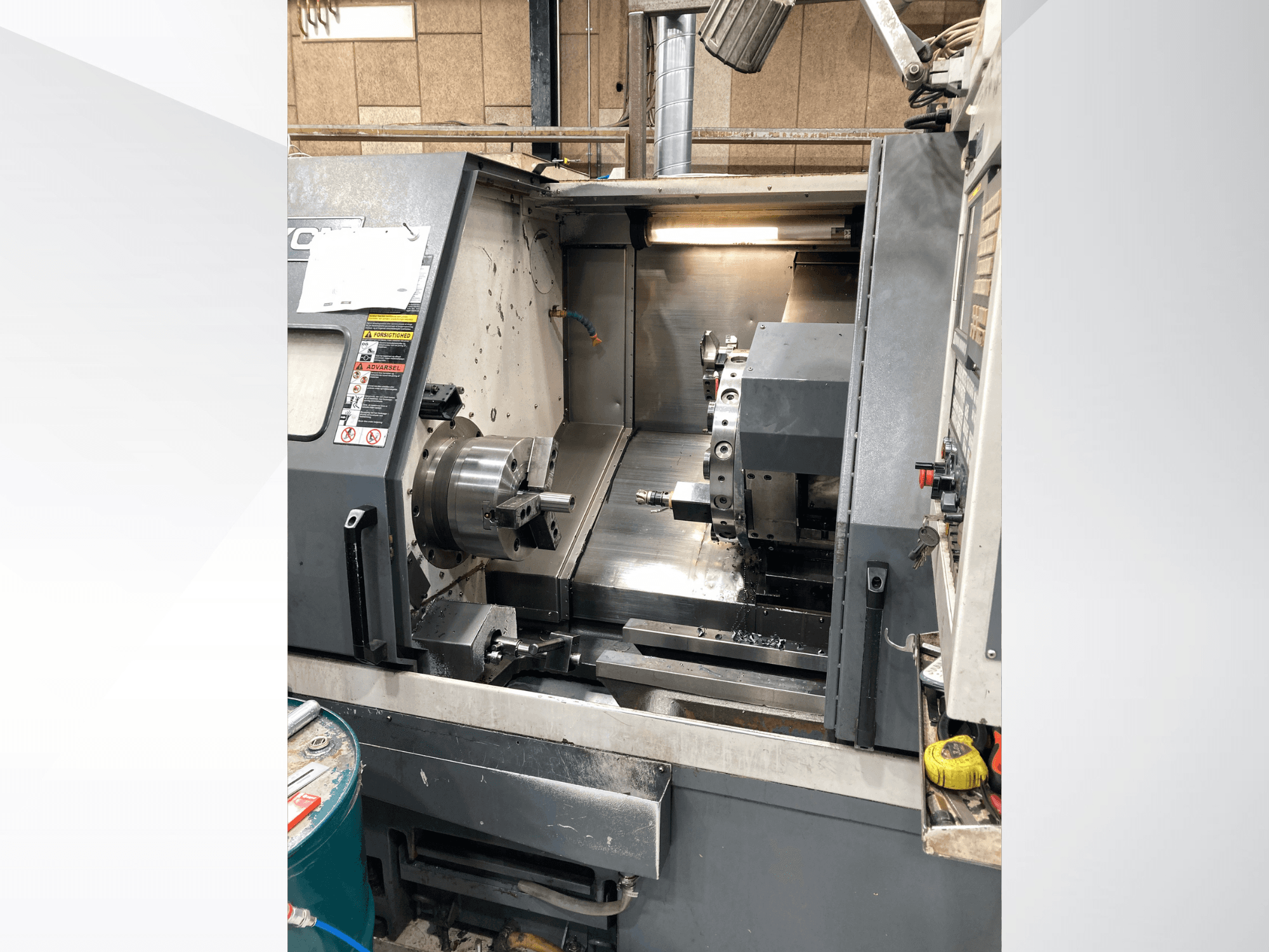 Torneiro horizontal YCM GT-300LMB, vista frontal, mostrando o painel de controlo e o mandril giratório com configuração de ferramentas.