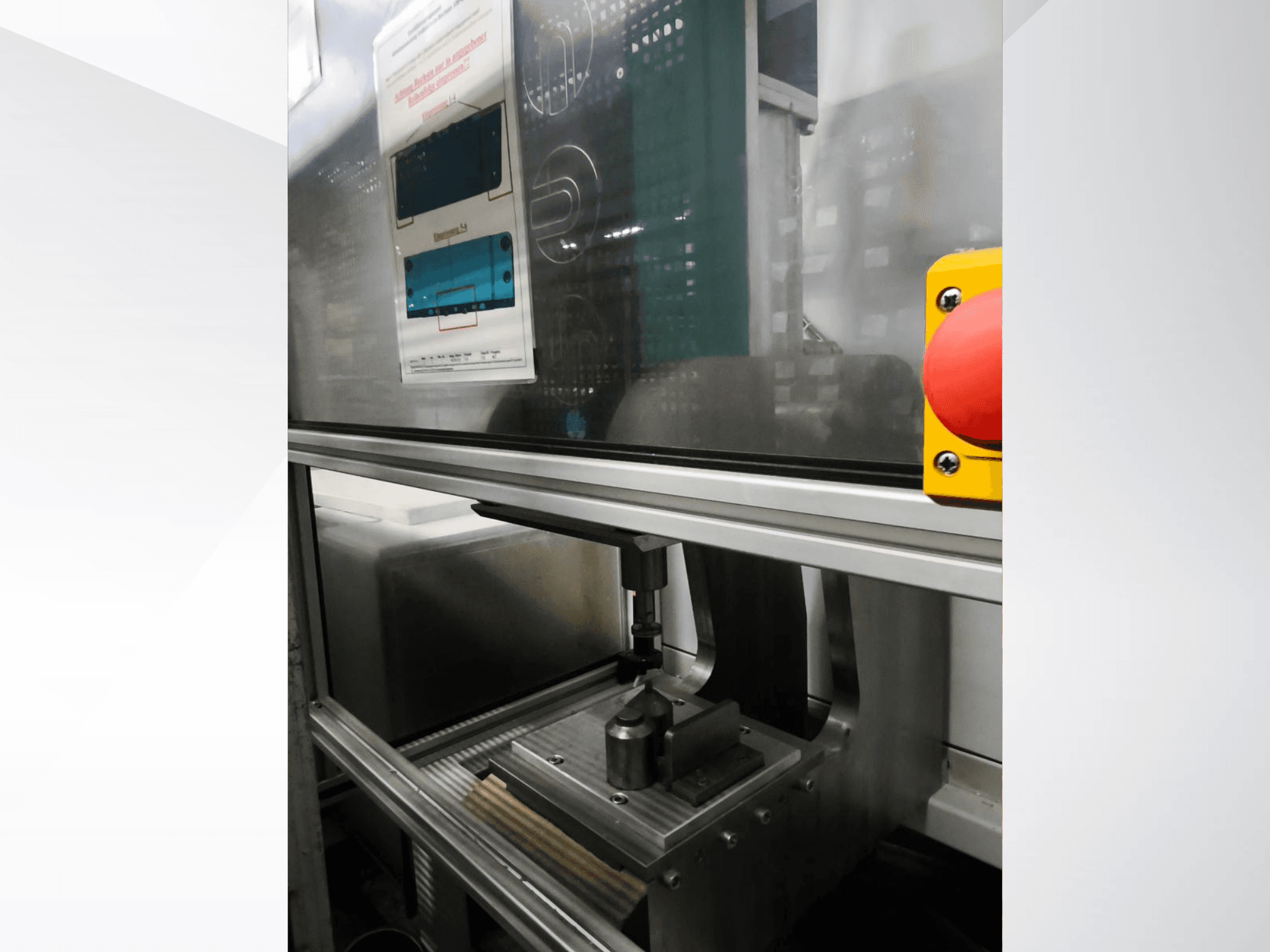 Vista frontal da máquina-ferramenta EMS Automation Buchsenpresse, mostrando o mecanismo de prensagem e o botão de segurança.