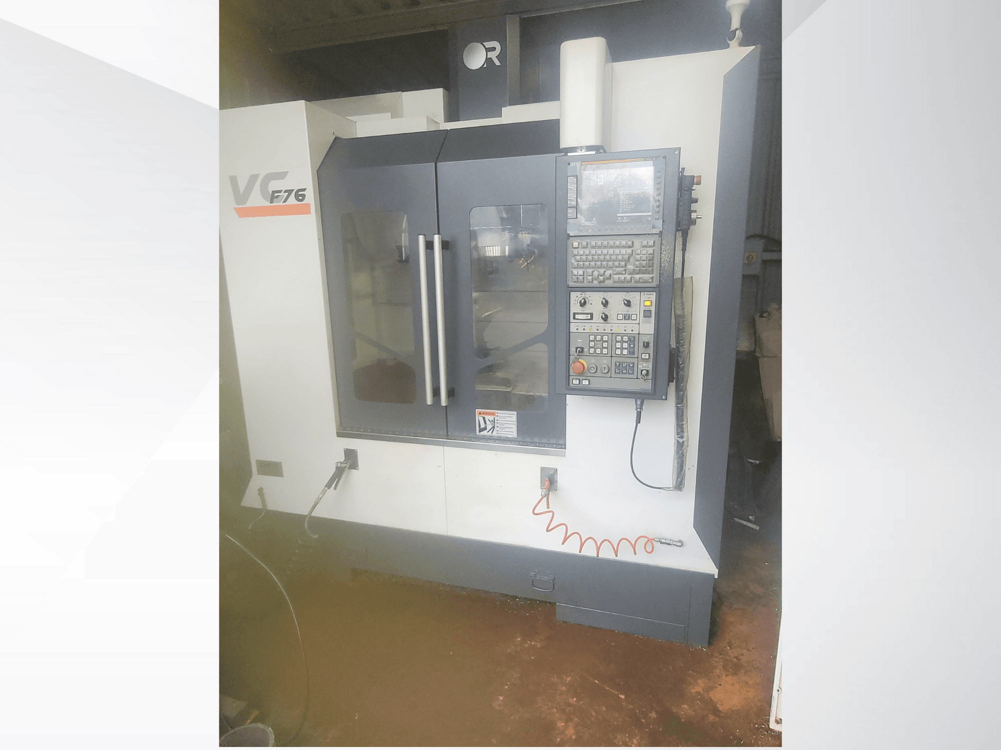 Centro de maquinação vertical, marca VC, modelo F76; vista frontal mostrando o painel de controlo e as portas de vidro.