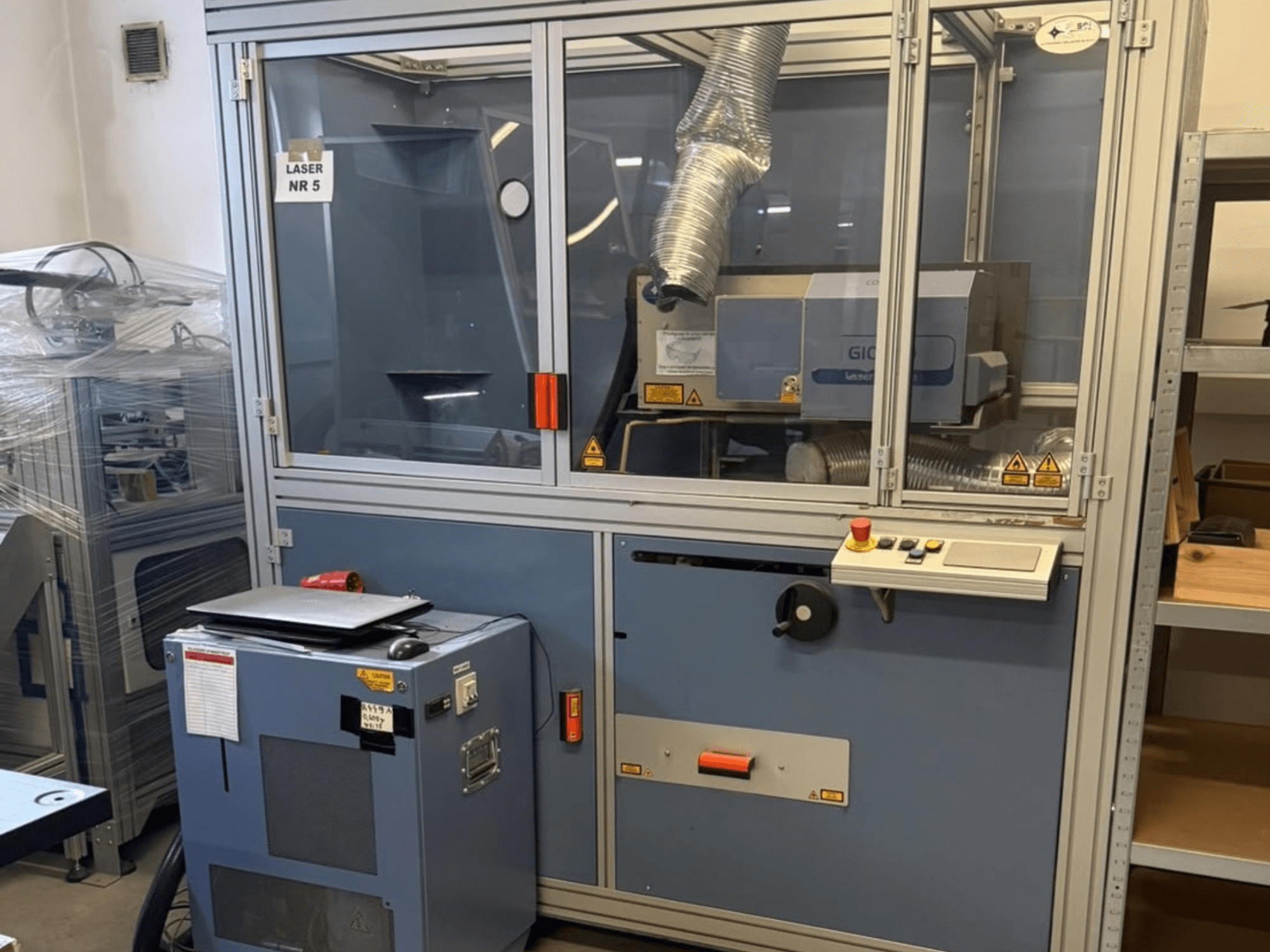 Máquina de corte a laser de CO₂ SEI Laser PAPER BLASTER 02, vista frontal, com painel de controlo e conduta de exaustão.