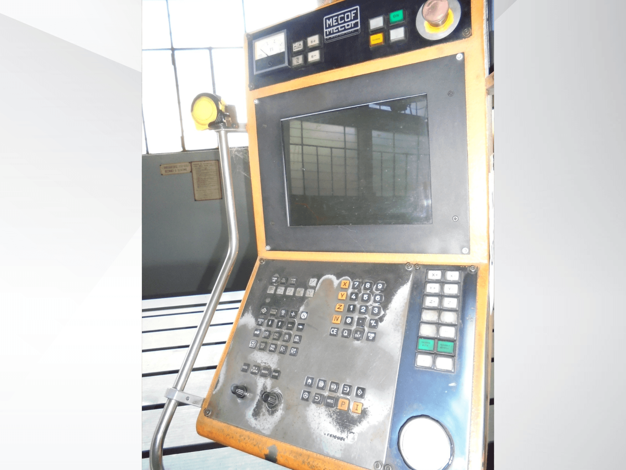 Painel de controlo Mecof com um visor digital, botões e manípulos; vista frontal mostrando o desgaste dos controlos.