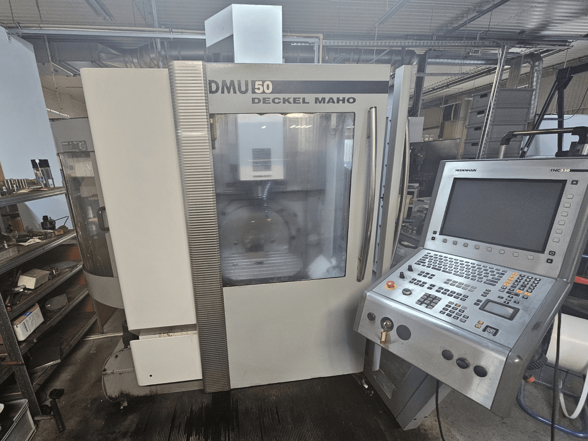 Máquina CNC DMU 50 Deckel Maho, vista frontal com painel de controlo e teclas de operação visíveis, numa oficina.
