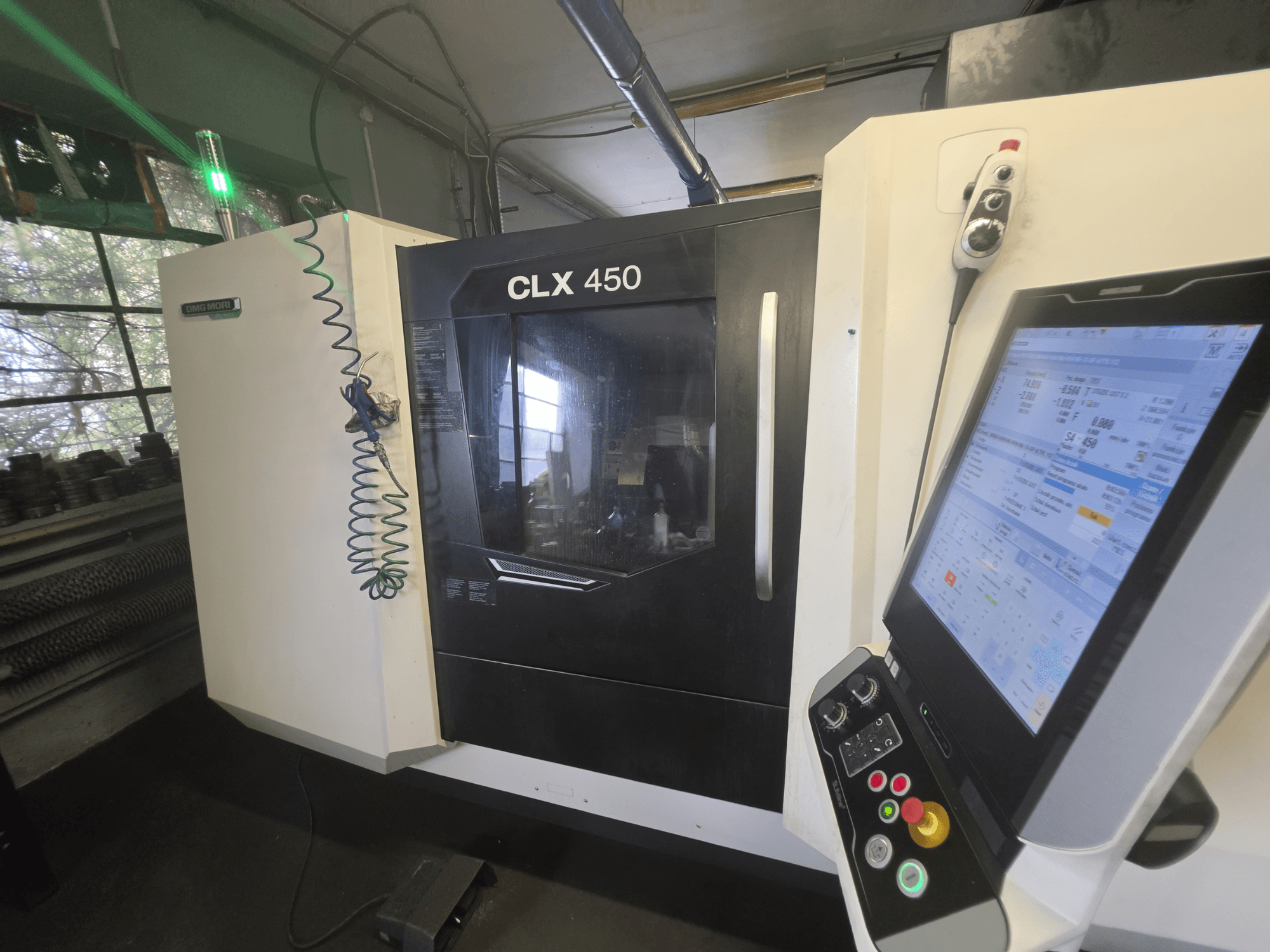 Torno horizontal DMG MORI CLX 450 V3, vista frontal com painel de controlo e monitor a apresentar dados operacionais.