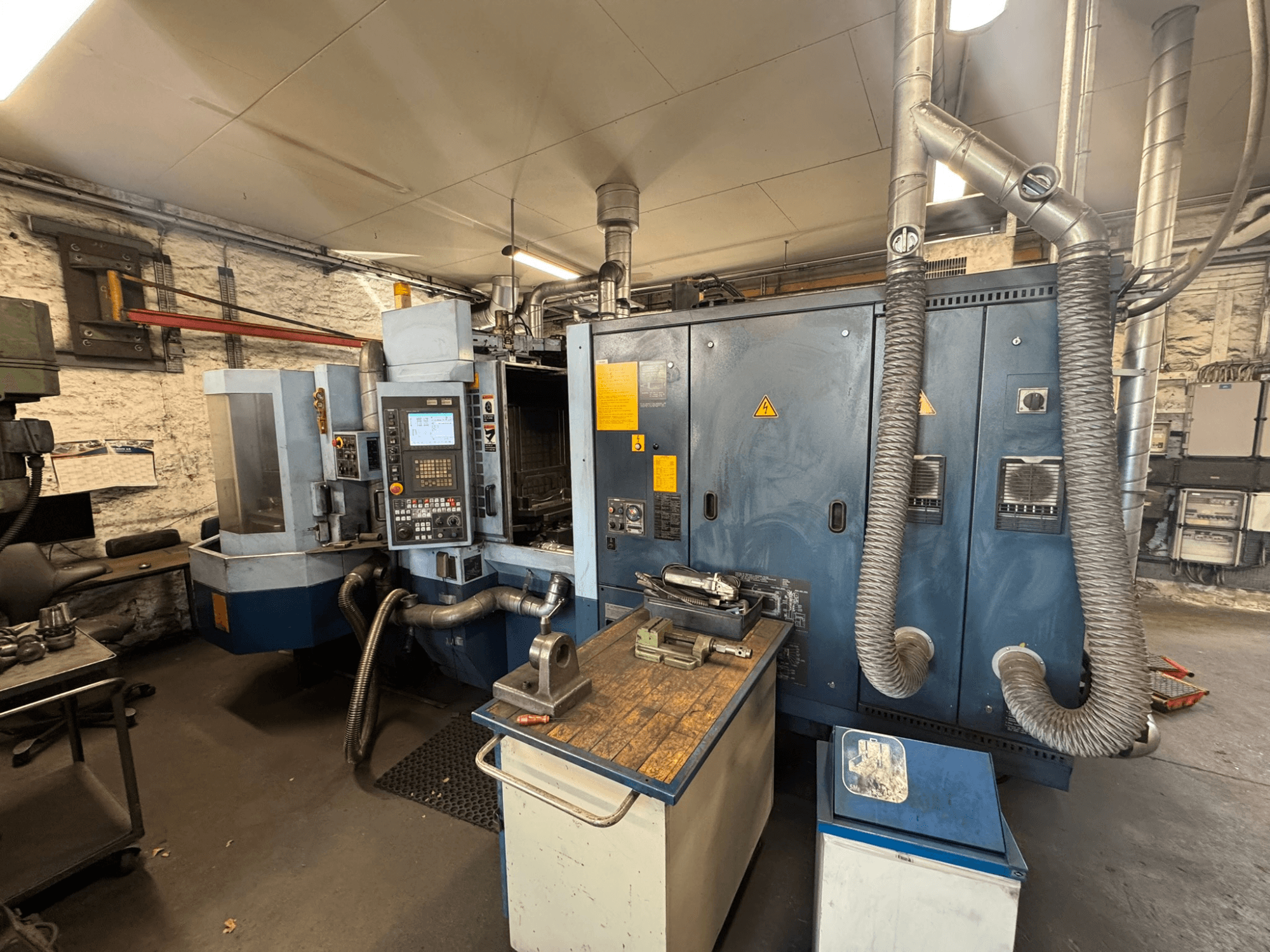 Centro de maquinagem horizontal Matsuura H.PLUS-300 numa oficina, vista frontal, mostrando o painel de controlo e a mesa de trabalho.