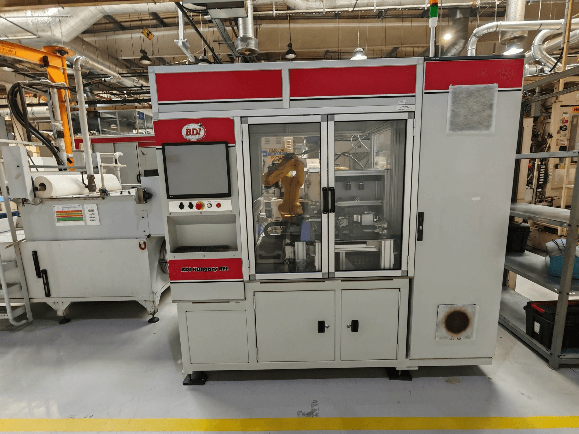 Máquina de retificação sem centros KOYO 4515C, vista frontal com o painel de controlo e o braço robótico visíveis, num ambiente fabril.