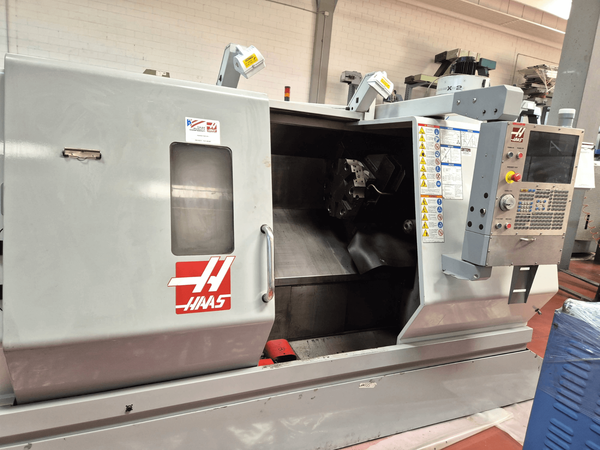 Torno horizontal Haas SL 30TBHE, vista frontal que mostra os comandos e o compartimento aberto para operações de maquinagem.