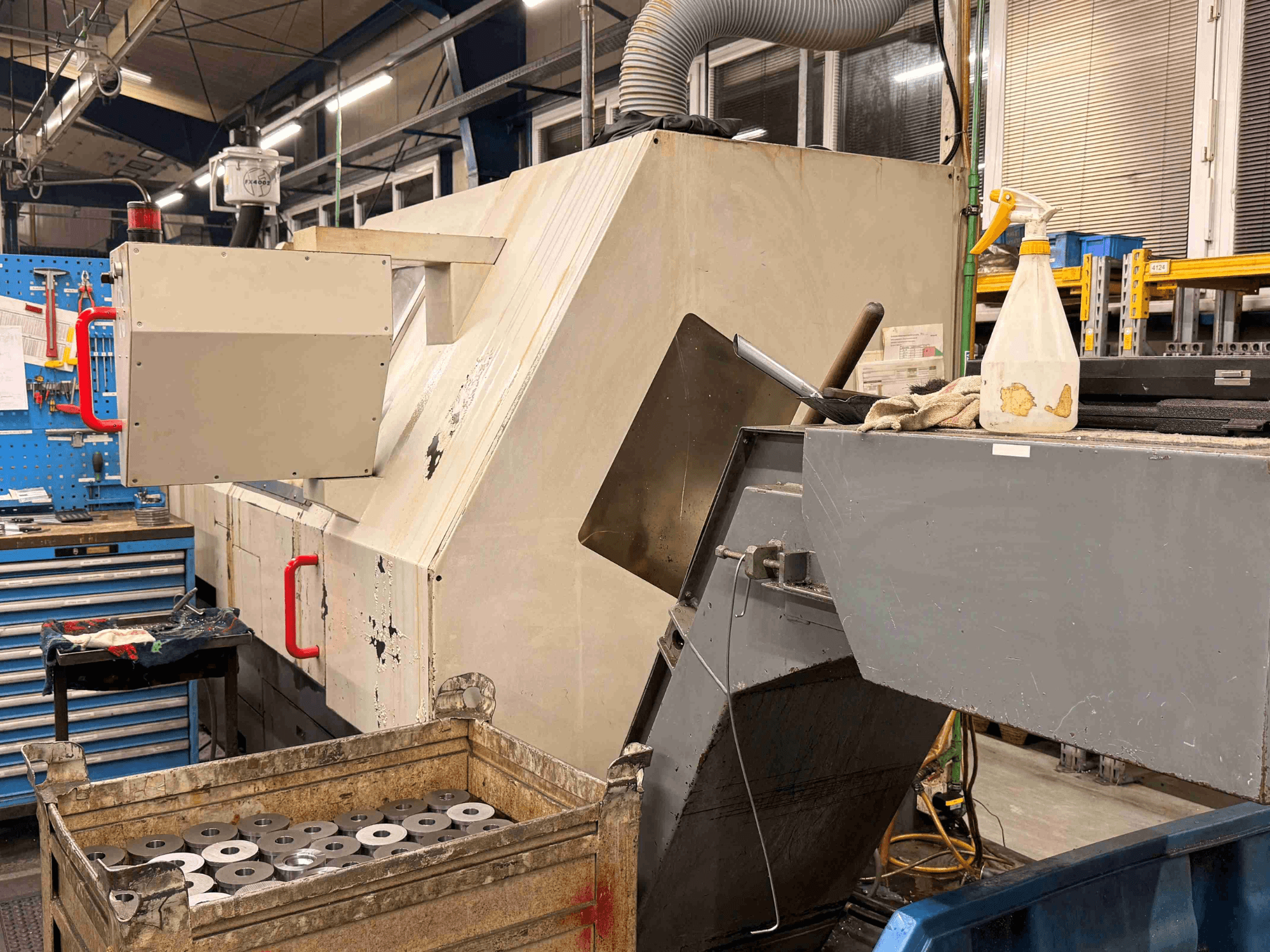 Torno horizontal CNC ZPS S-60 na oficina, apresentando uma vista lateral com peças de trabalho e comandos visíveis.