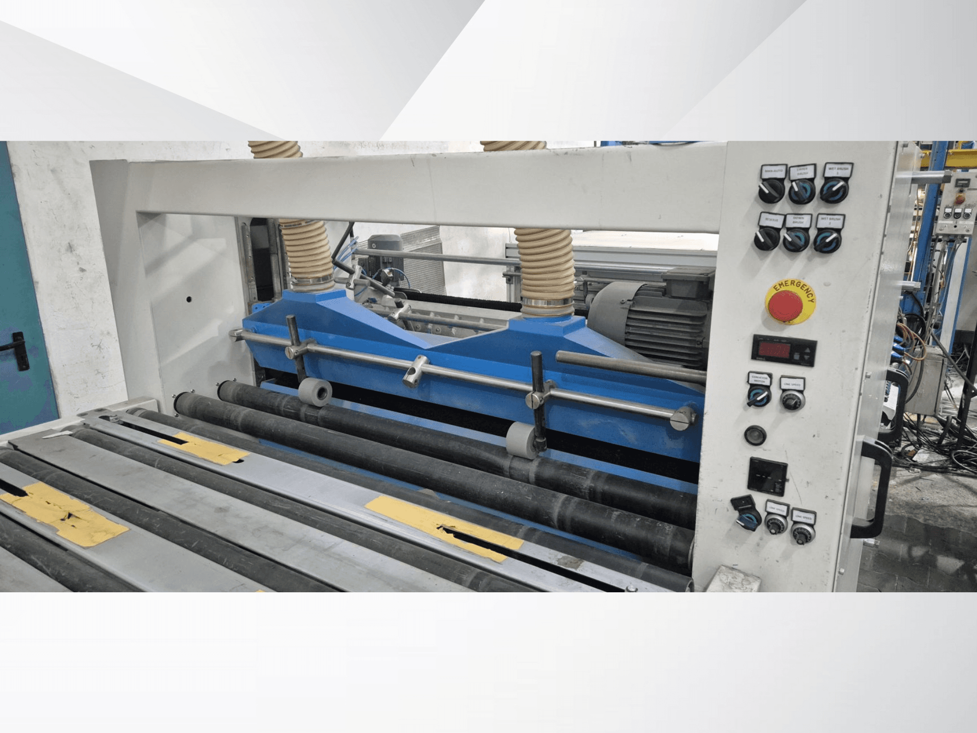 Máquina de laminagem industrial com componentes azuis, vista frontal, com painel de controlo e botão de paragem de emergência.