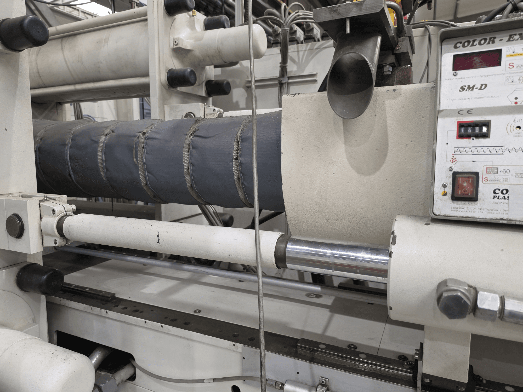 Máquina de moldagem por injeção hidráulica Krauss Maffei 350-3000 CX, vista lateral mostrando o painel de controlo da temperatura e os elementos de aquecimento.