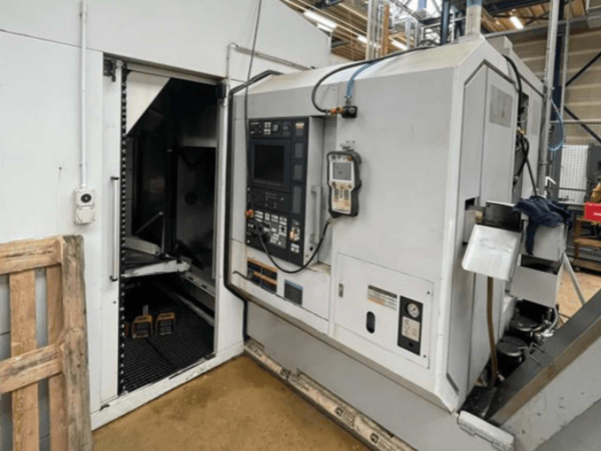 Torneiro horizontal DMG Mori Seiki NZ2000T3Y2, vista lateral mostrando o painel de controlo e o interior da máquina.