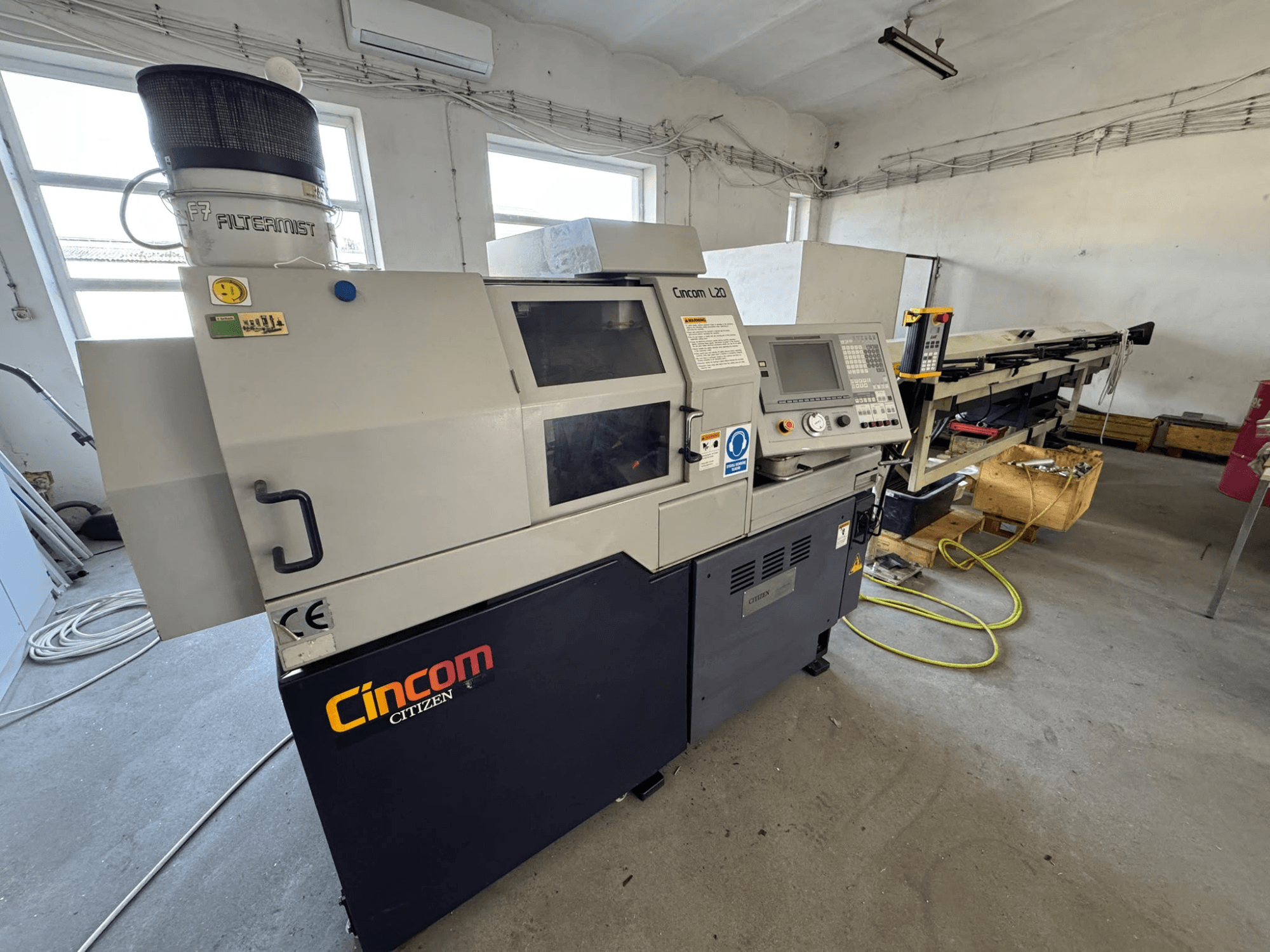 Torno Citizen Cincom L20 VII de tipo suíço, visto de frente, mostrando o painel de controlo e o sistema de refrigeração.