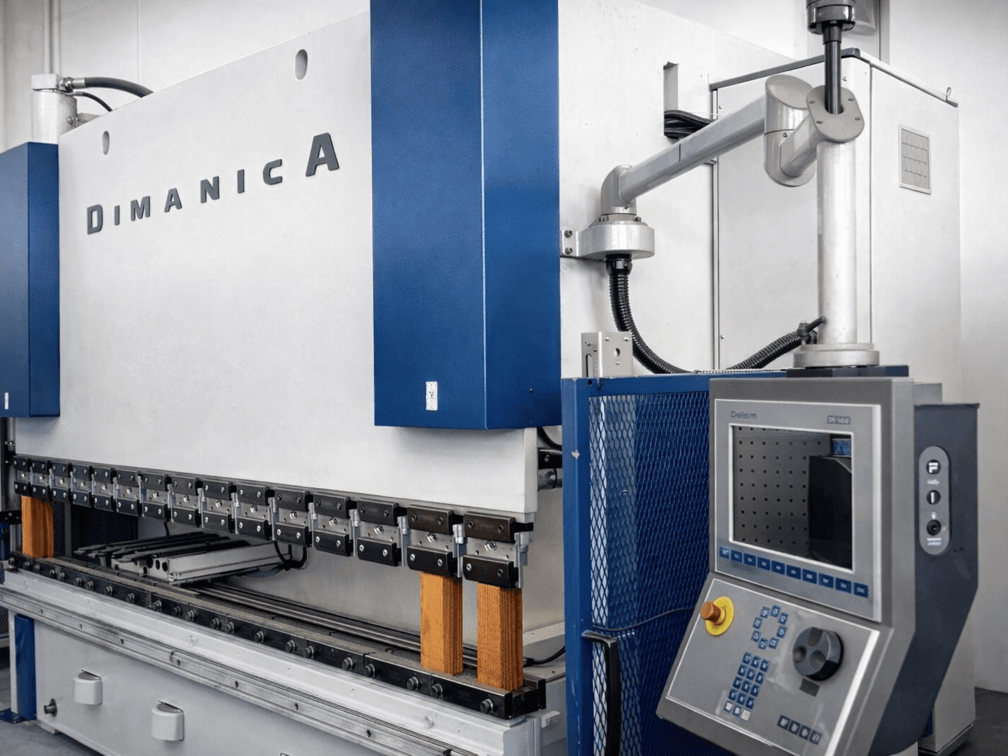 Prensa dobradeira DINAMICA 3000x100 da Warcom, vista lateral mostrando o painel de controlo e as ferramentas de dobragem para o fabrico de metal.