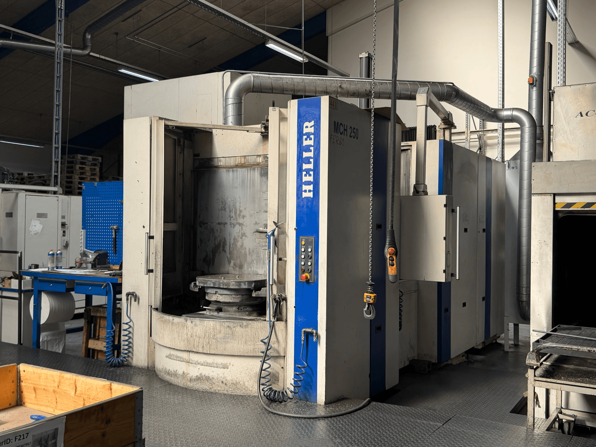 Vista frontal do centro de maquinação horizontal HELLER MCH 250 com painel de controlo, grande mesa rotativa e ambiente industrial.