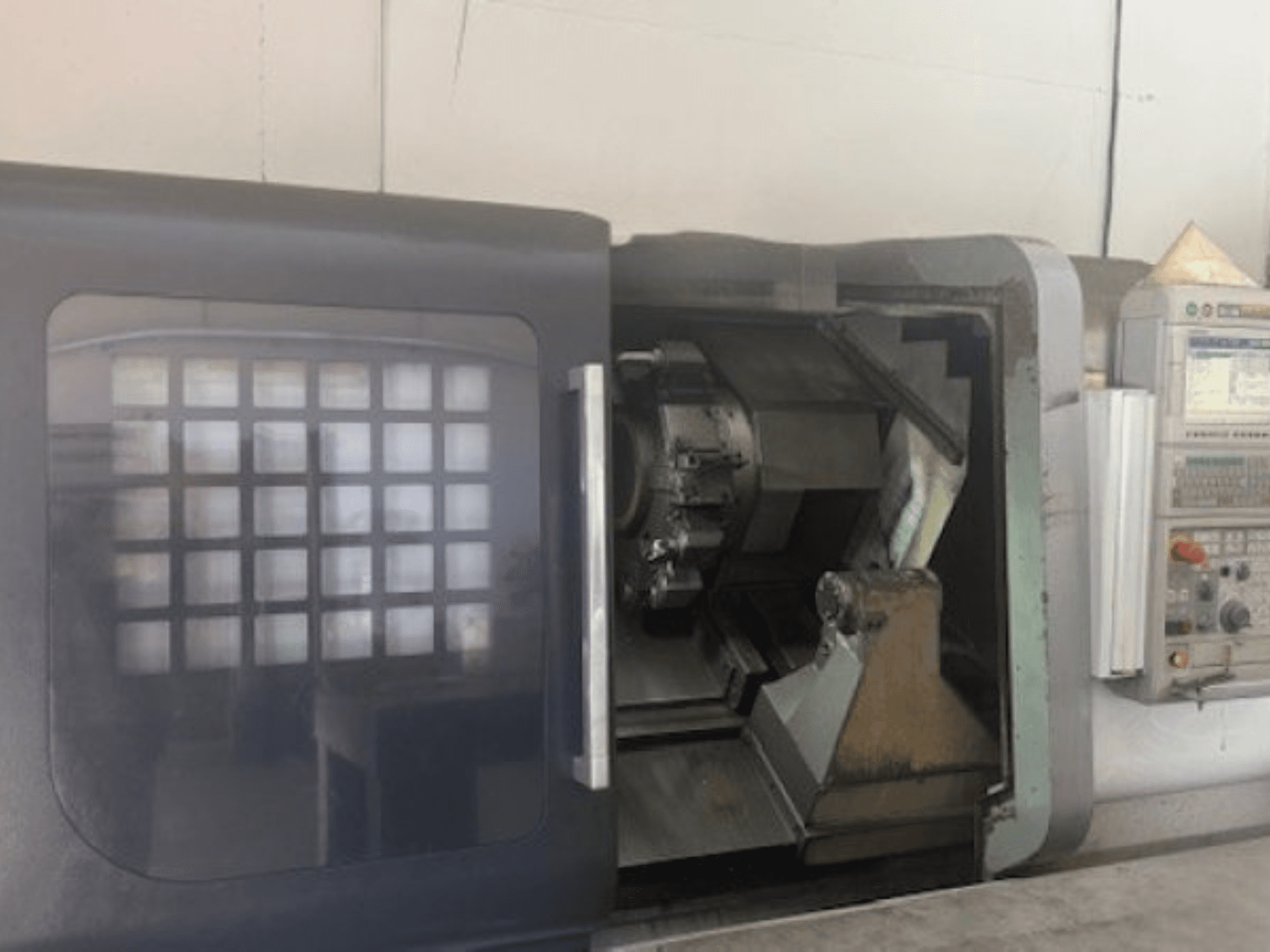 Torneiro horizontal MORI SEIKI NLX 2500M, vista frontal mostrando o suporte da ferramenta, painel de controlo e mecanismo interior.