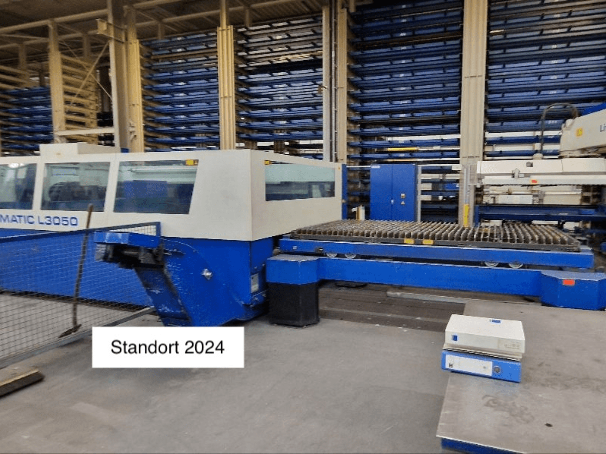 Máquina de corte a laser TRUMPF Trumatic L3050 CO2 em vista frontal, com uma grande base de corte e painel de controlo.