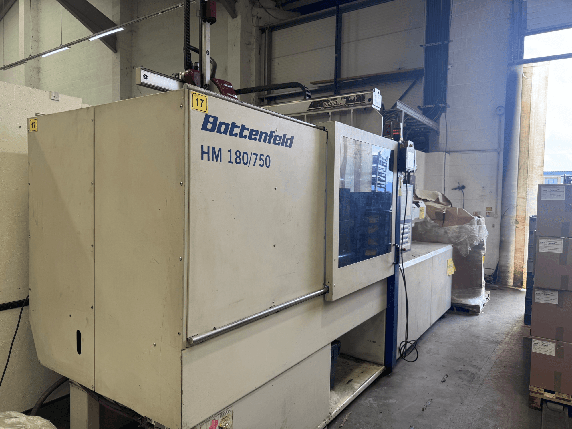 Máquina de moldagem por injeção hidráulica Battenfeld HM150750 vista de frente, mostrando o painel de controlo e a configuração envolvente.