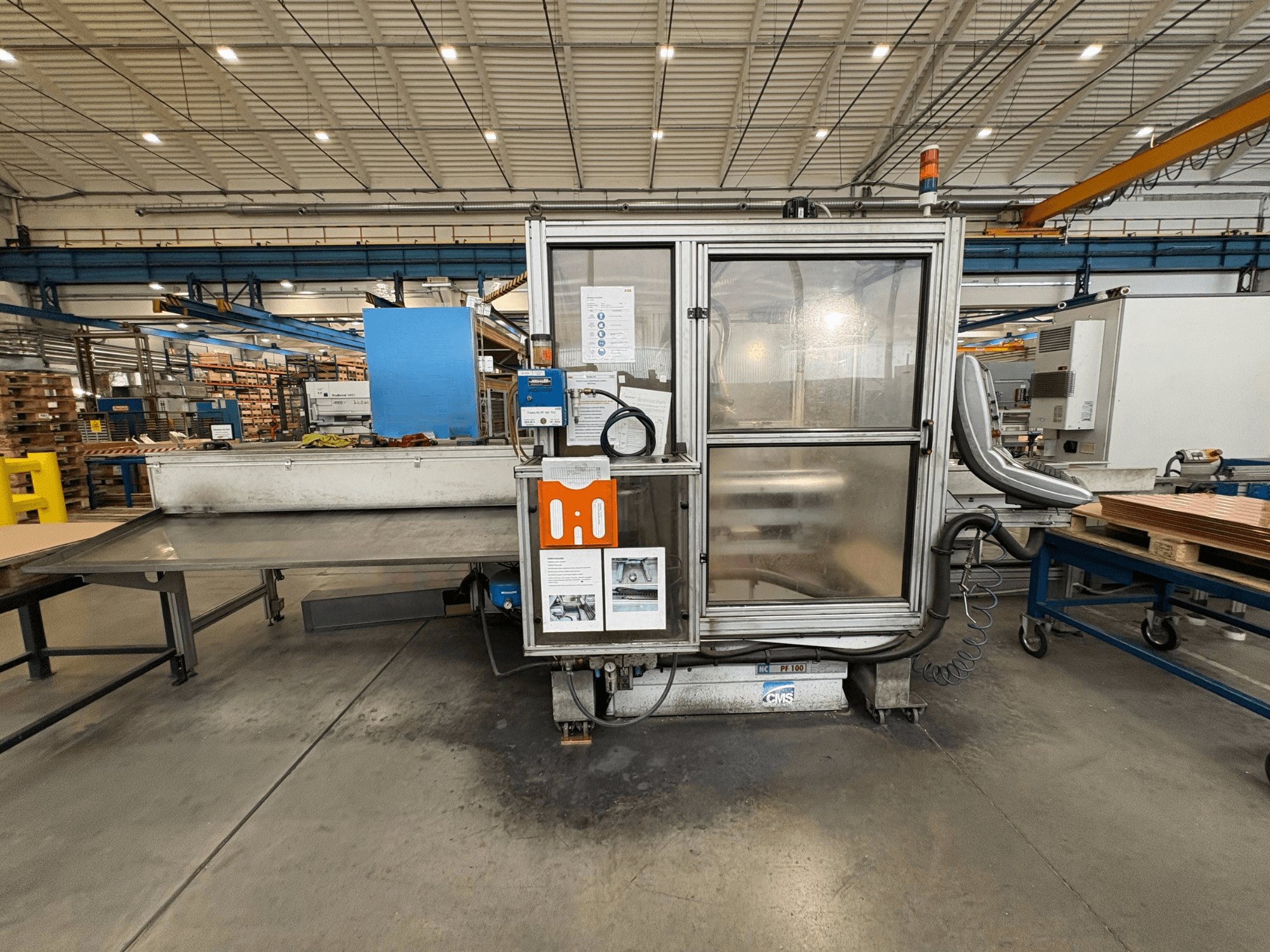Centro de maquinação CNC para madeira CMS NC PF 100, vista frontal; possui painel de controlo, caixa de segurança e mesa de trabalho.