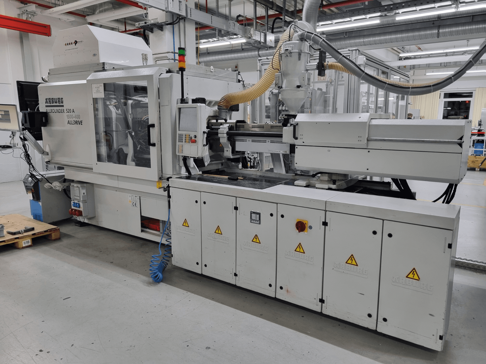 Máquina de moldagem por injeção Arburg Allrounder 520 A, vista lateral, mostrando o painel de controlo e as caraterísticas de segurança.