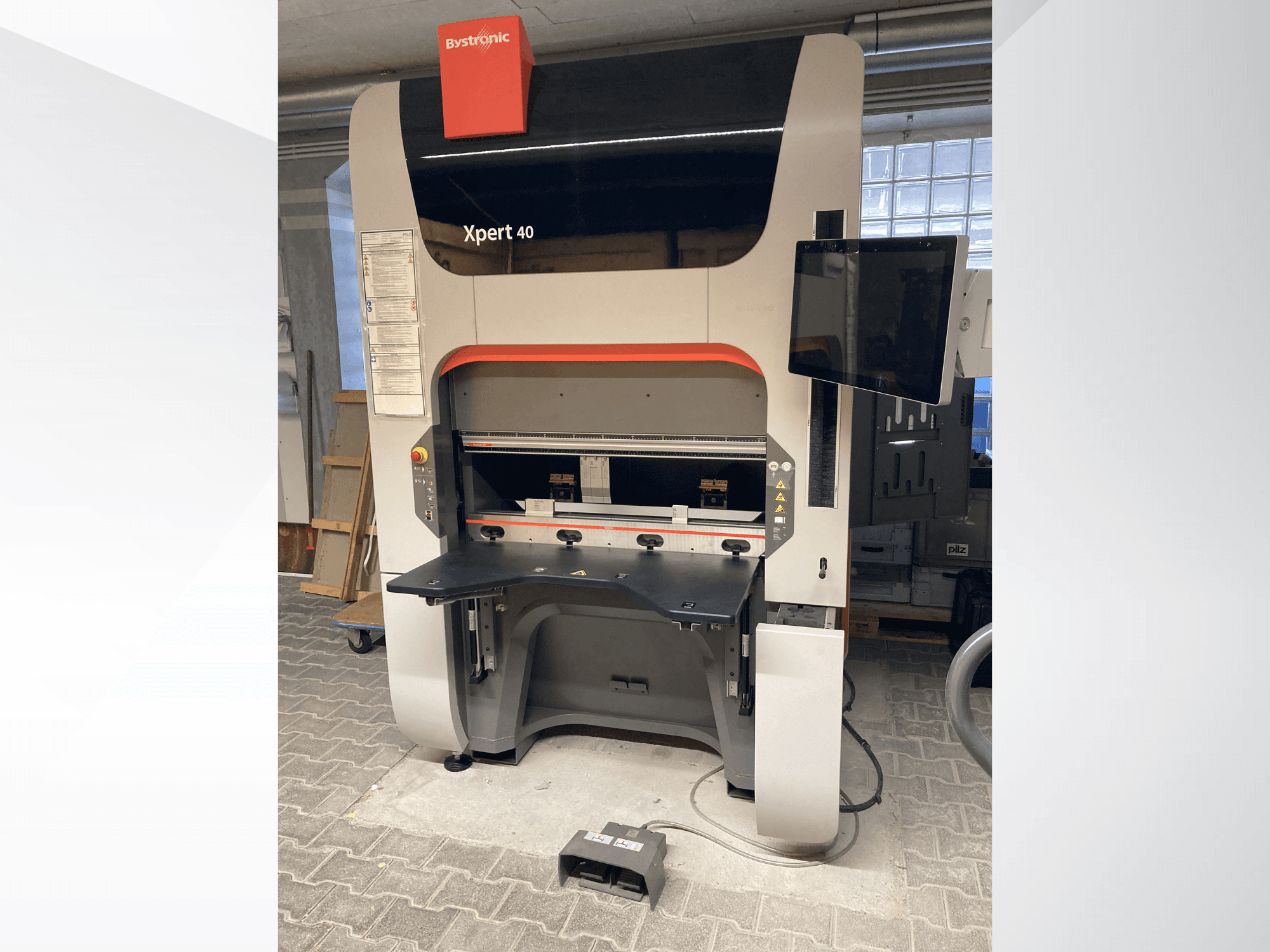 A prensa dobradeira Bystronic Xpert 40/1030 em vista frontal, mostrando o painel de comando, a superfície de trabalho e o monitor acoplado.
