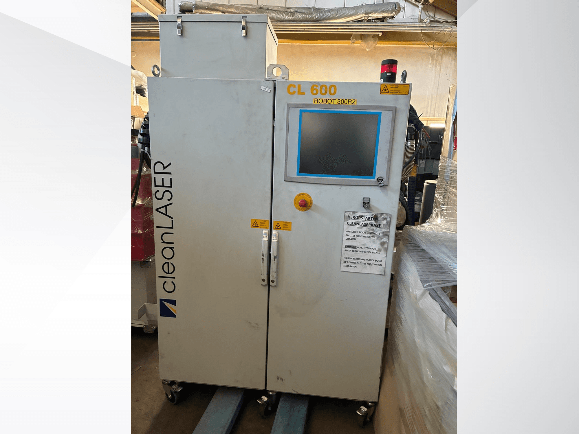 Sistema de automatização CLEAN LASER CL 600, visto de frente, com ecrã LCD, etiquetas de aviso e botões de controlo na porta.