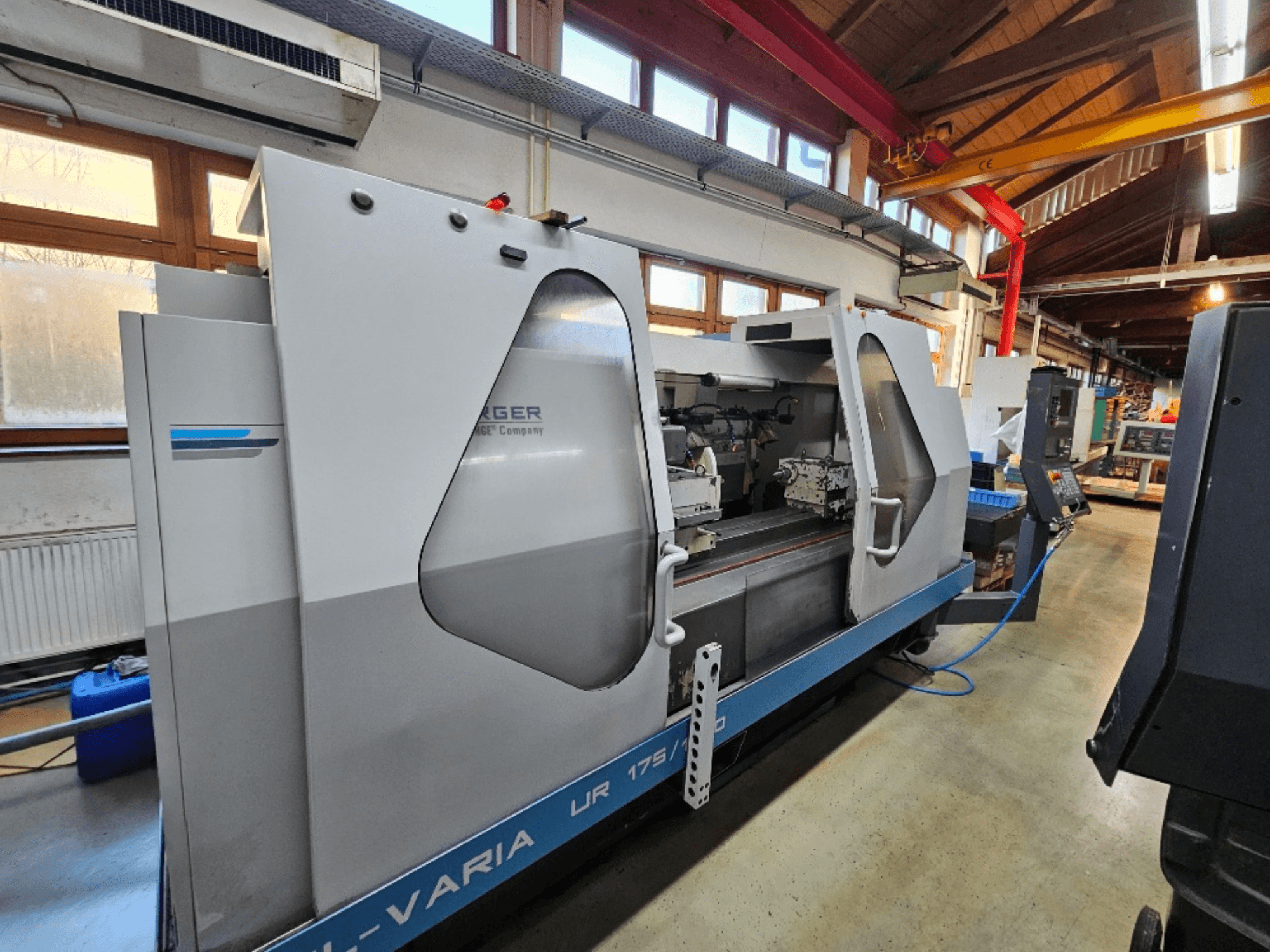 Máquina CNC da Burg, modelo UR 175/300, vista lateral. Apresenta um design elegante com controlos e área de trabalho visíveis.