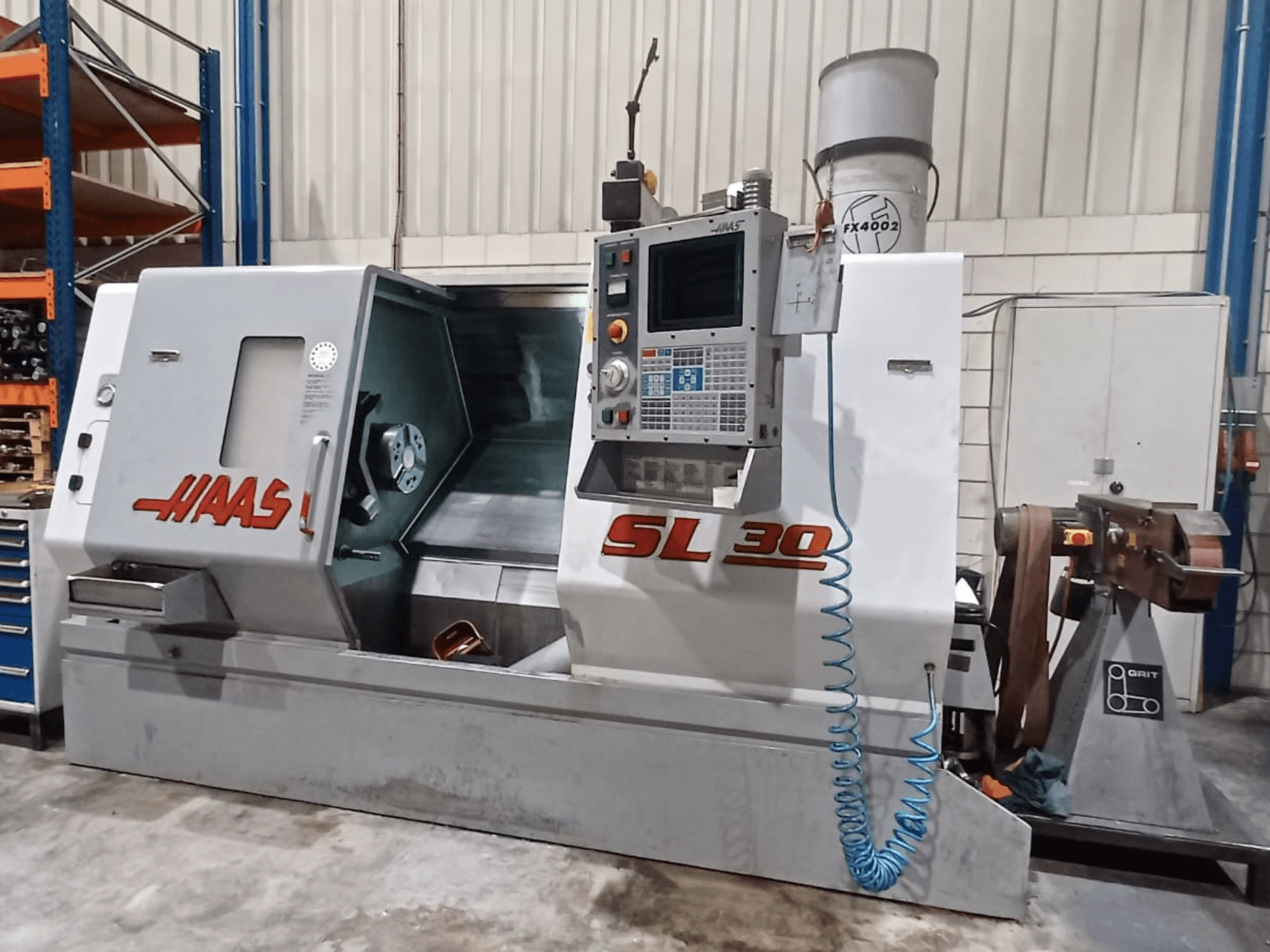 Torno CNC SL 30 da Haas em vista lateral, mostrando o painel de controlo, a área de maquinação e o sistema de refrigeração integrado para metalurgia.