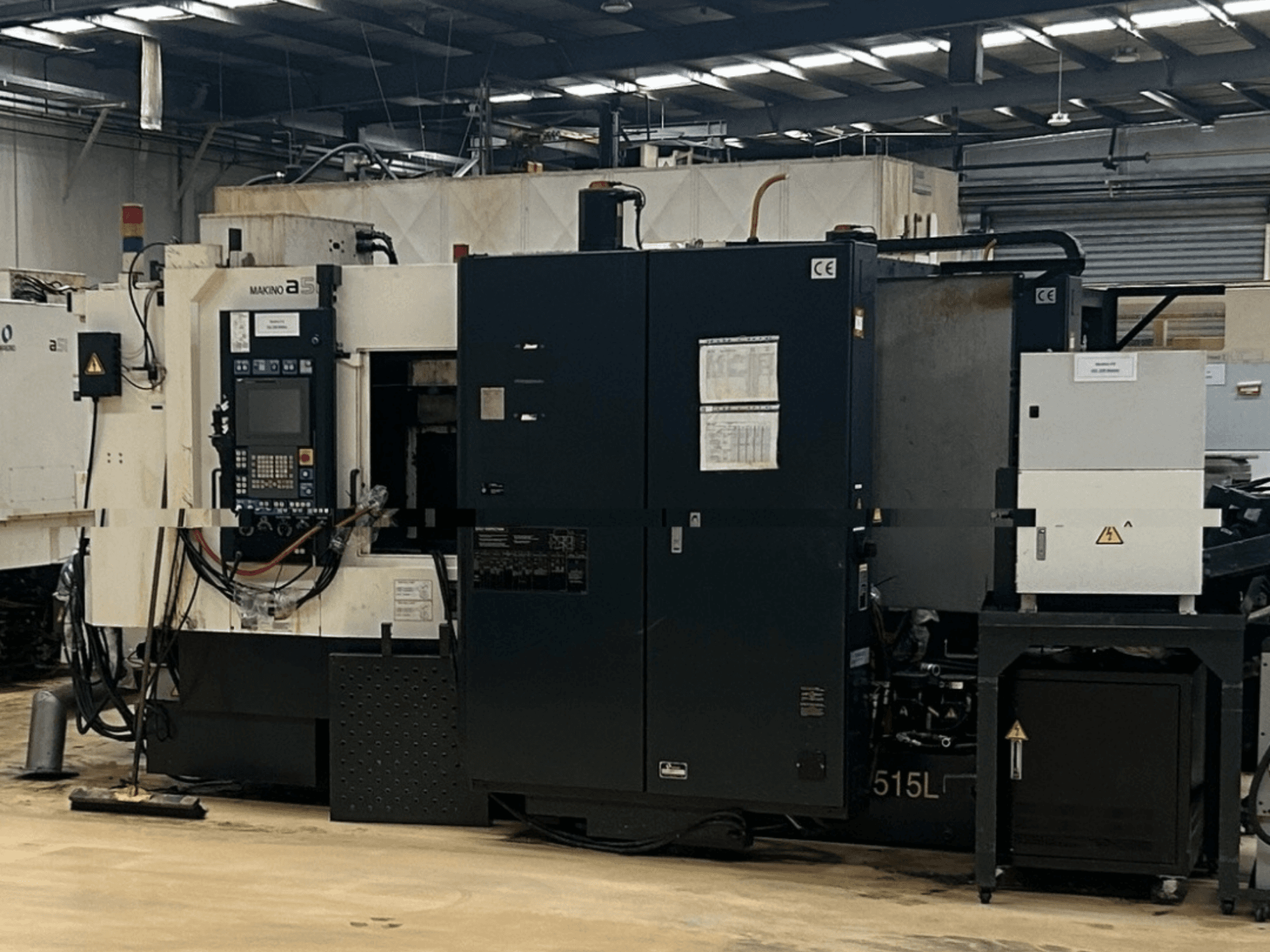 Centro de maquinagem horizontal Makino A51-5XR, vista frontal que mostra o painel de controlo, a fonte de alimentação e os componentes da máquina.