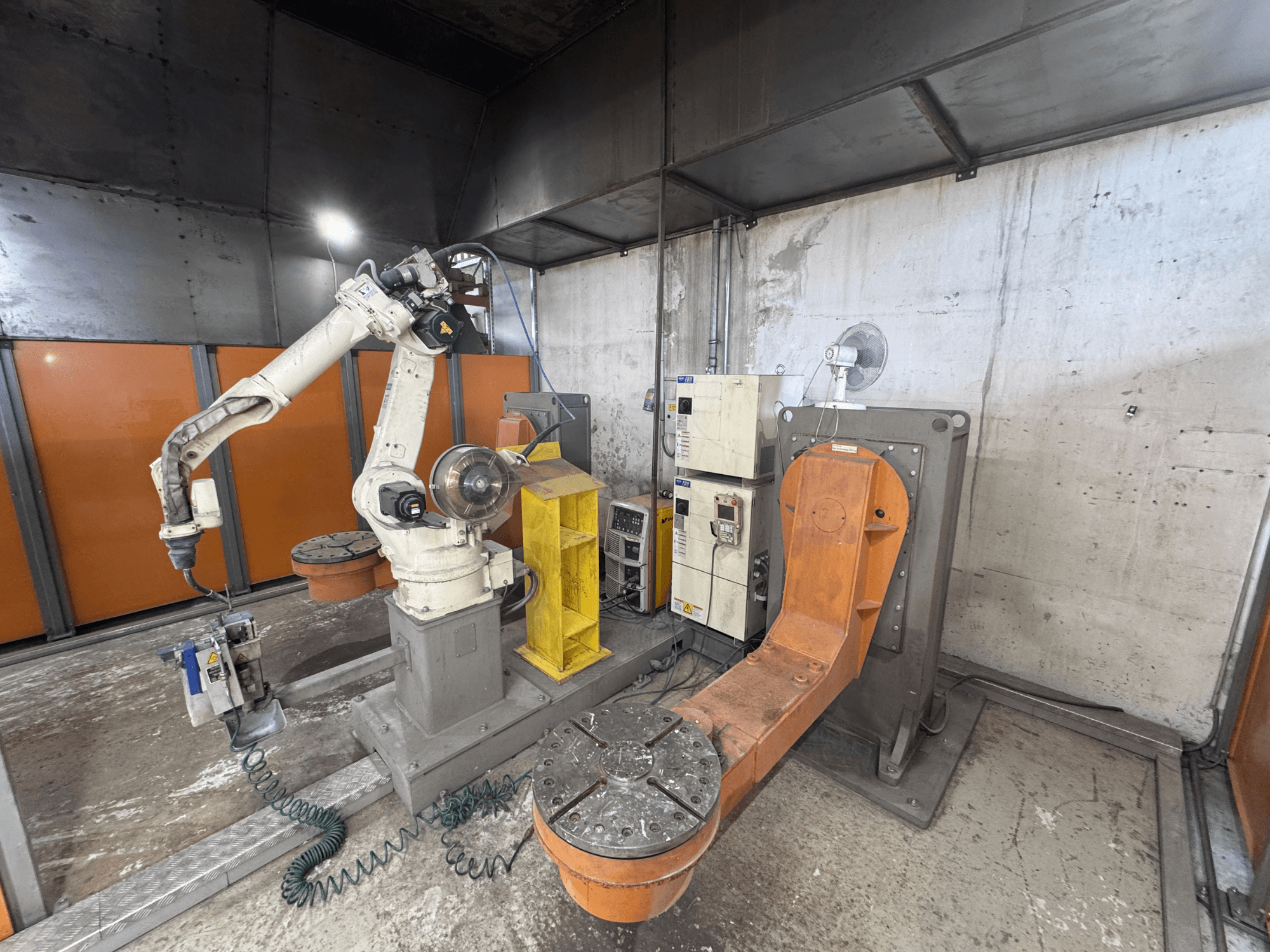 Braço robótico DAIHEN VARSTROJ FD-B4L 1GM/2DM em ambiente industrial, vista lateral com painel de controlo e base giratória visíveis.