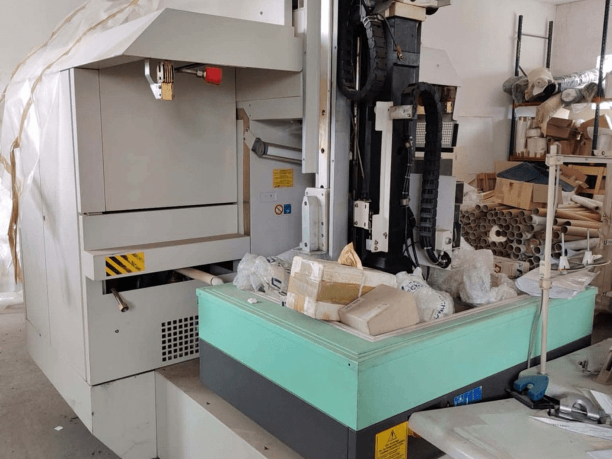 AGIE AGIETRON INTEGRAL 2, máquina de electroerosão por penetração, vista frontal, mostrando o painel de controlo, a mesa de trabalho e a desordem circundante.