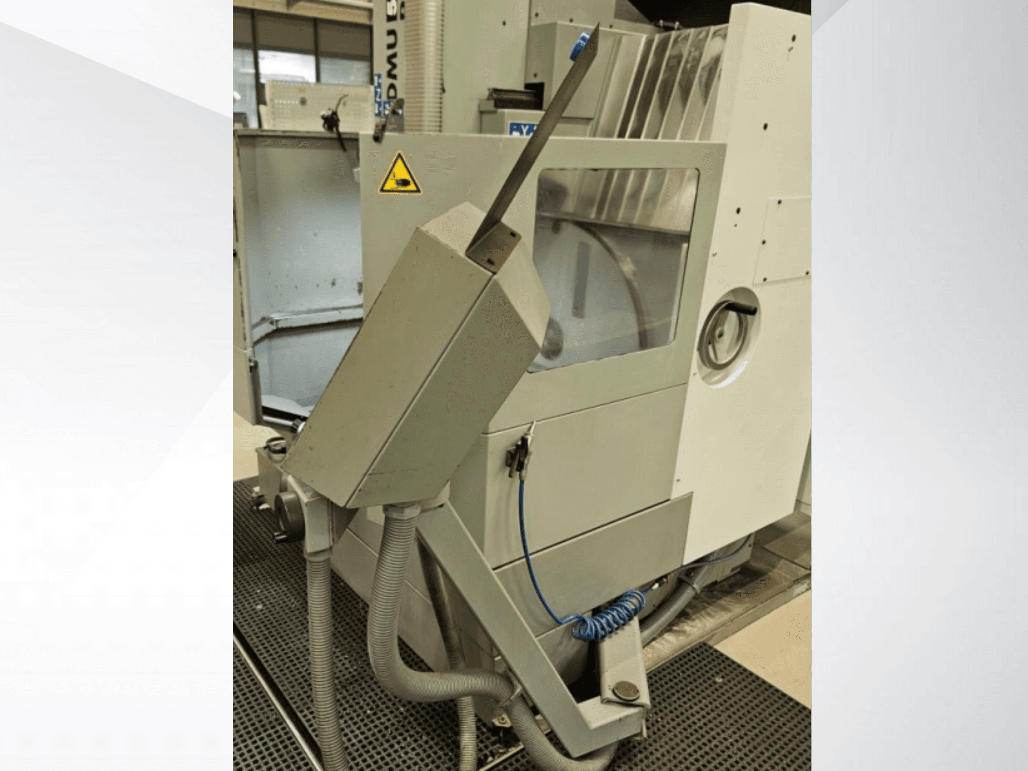 Vista lateral da fresadora DMU com bocal de refrigeração e painel de controlo integrado; inclui etiqueta de aviso de segurança.
