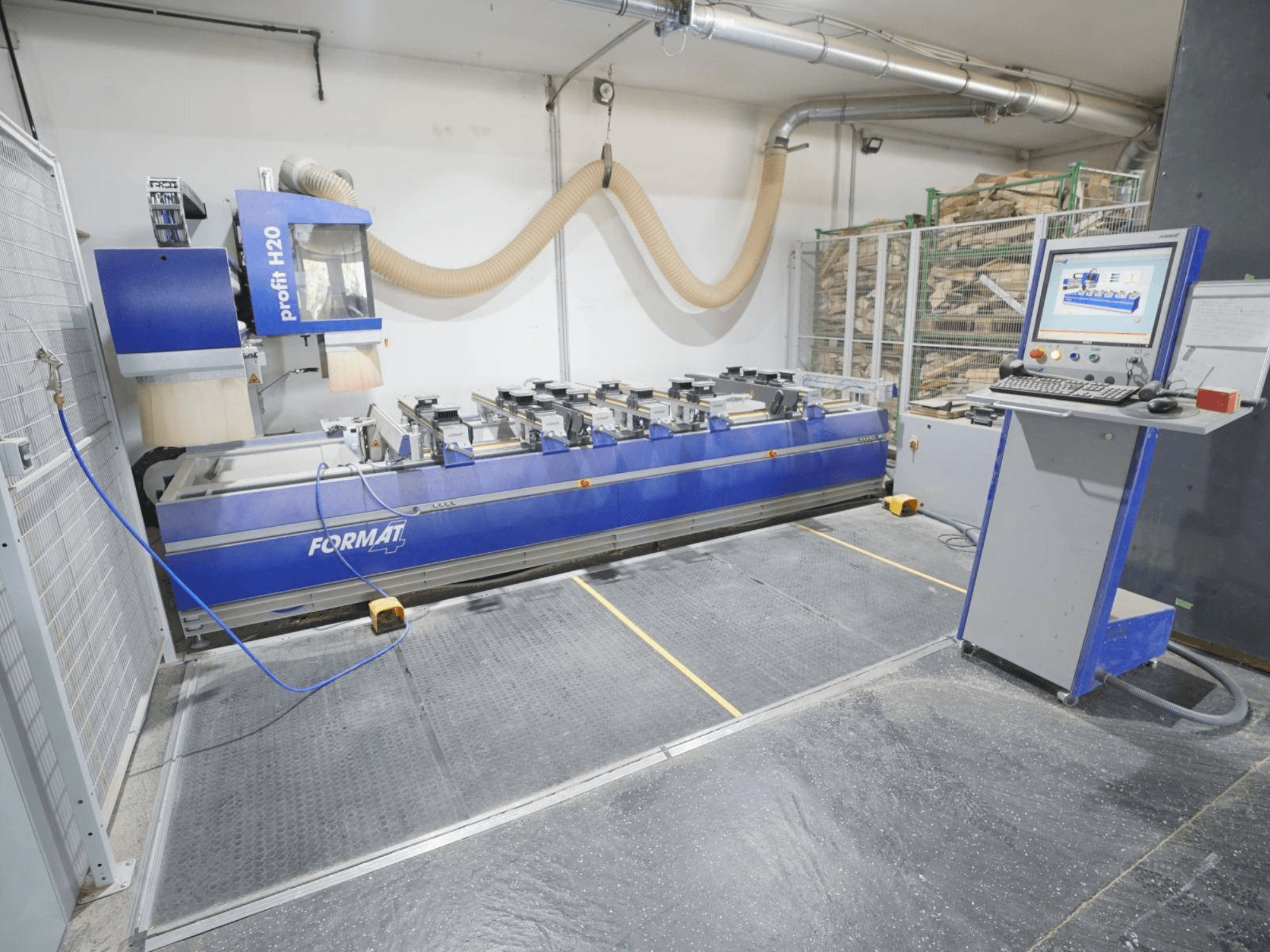Centro de maquinagem de madeira CNC FORMAT4 PROFIT H20, vista frontal com o painel de controlo e as ferramentas de corte visíveis num ambiente industrial.