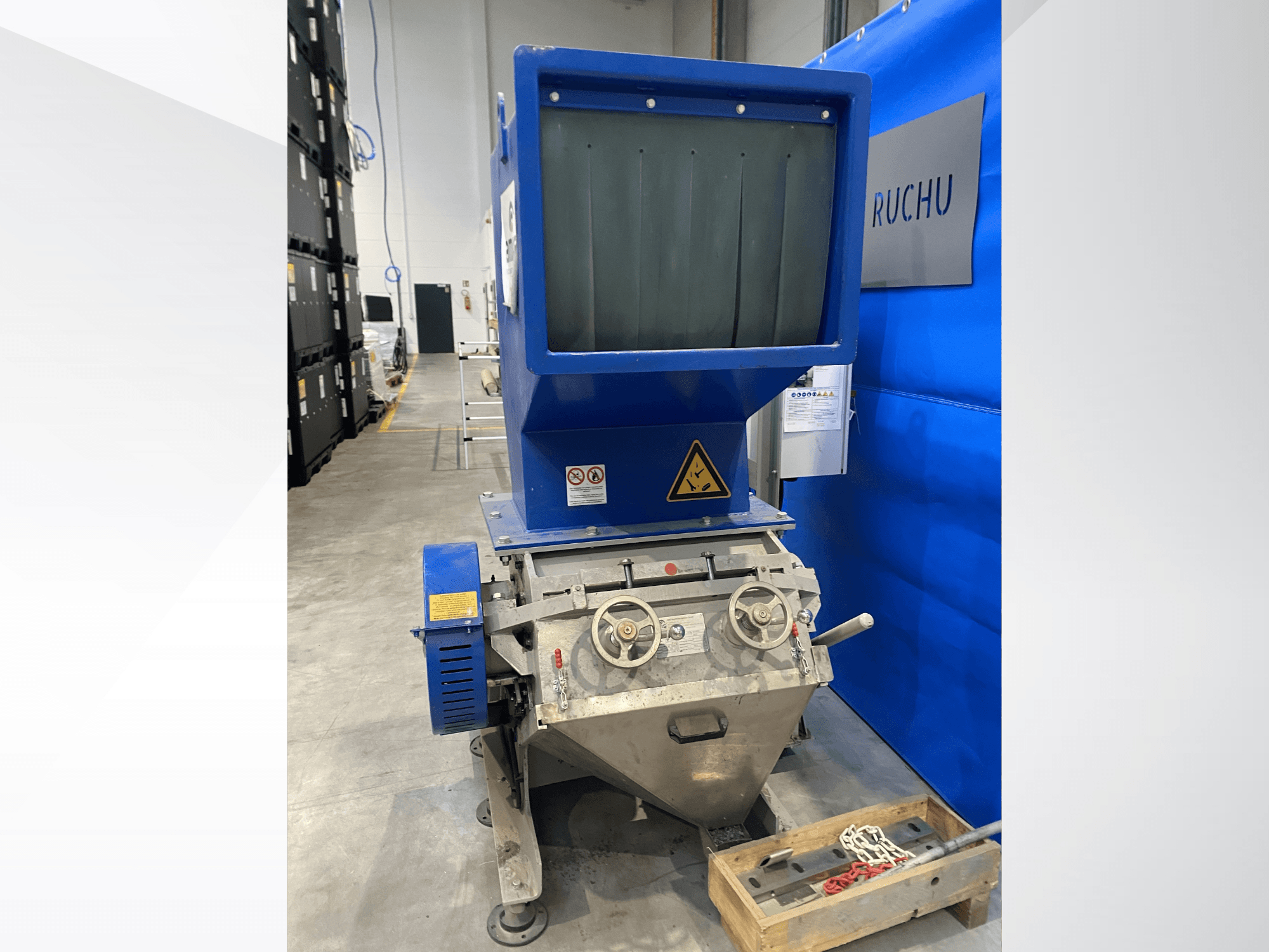 Vista frontal da máquina de processamento de plástico AMIS GSE 300/600 com tremonha azul, botões de controlo e etiquetas de aviso.