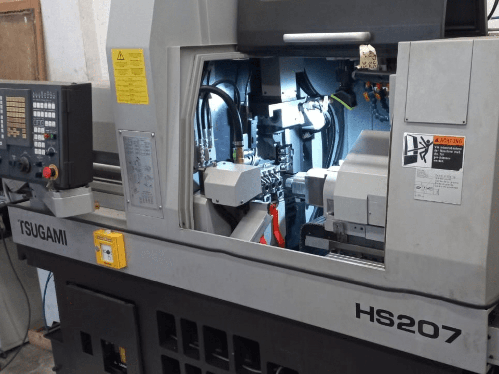 Torno de tipo suíço TSUGAMI HS207, vista frontal que mostra o painel de controlo e os componentes internos.