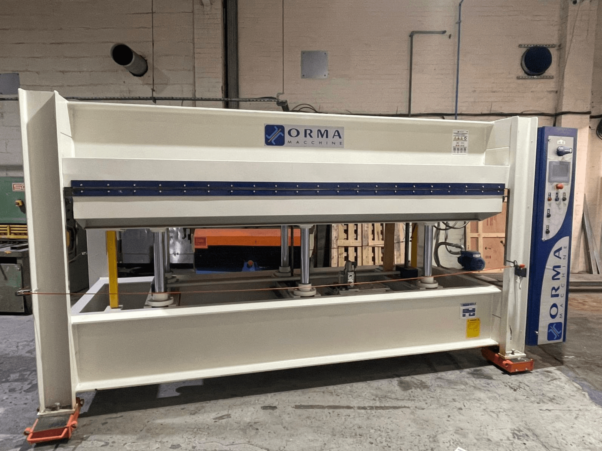 Prensa hidráulica ORMA machinery, vista frontal, com acabamento prateado, painel de controlo à direita e pistões verticais para prensagem.