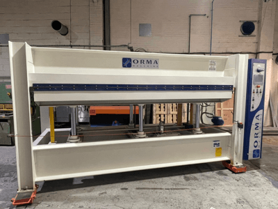 Prensa hidráulica ORMA machinery, vista frontal, com acabamento prateado, painel de controlo à direita e pistões verticais para prensagem.