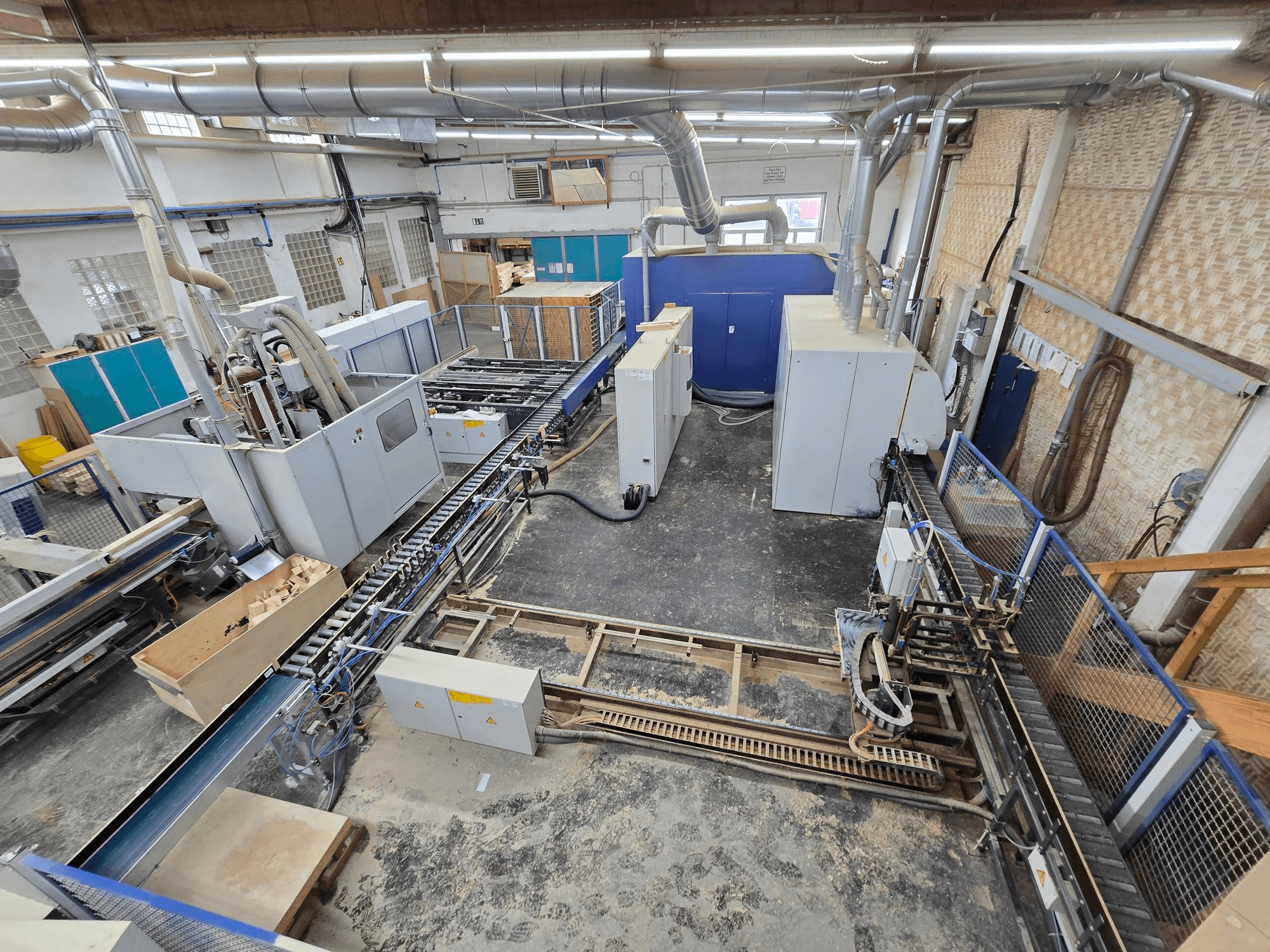 WEINIG DIMTER Unirex 2000 SPB linha completa de produção de madeira numa fábrica, vista aérea mostrando a maquinaria e o sistema de transporte.