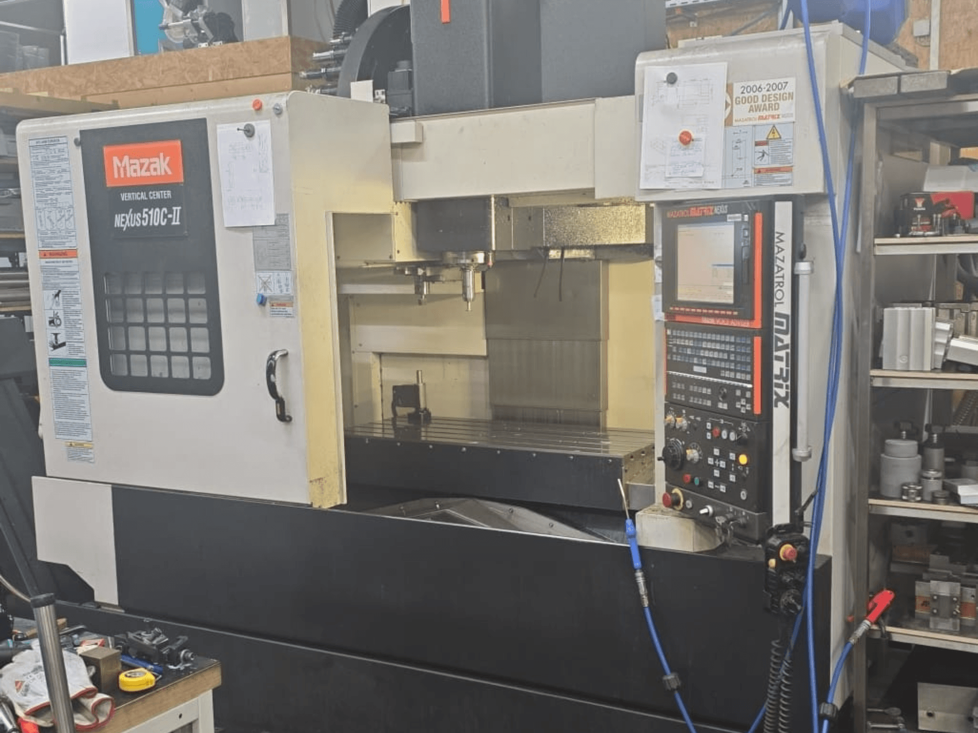 Mazak VERTICAL CENTER NEXUS 510C-II, vista frontal mostrando o painel de controlo, área de maquinação e caraterísticas operacionais.