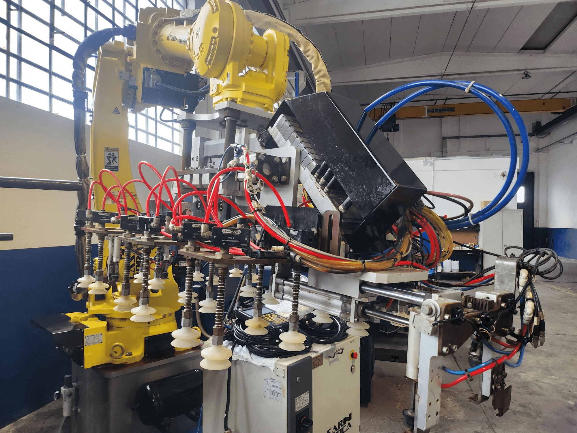 Braço do robô Hyundai Hi 5a-S numa vista frontal, com várias mangueiras, componentes de controlo e uma disposição complexa de cabos.