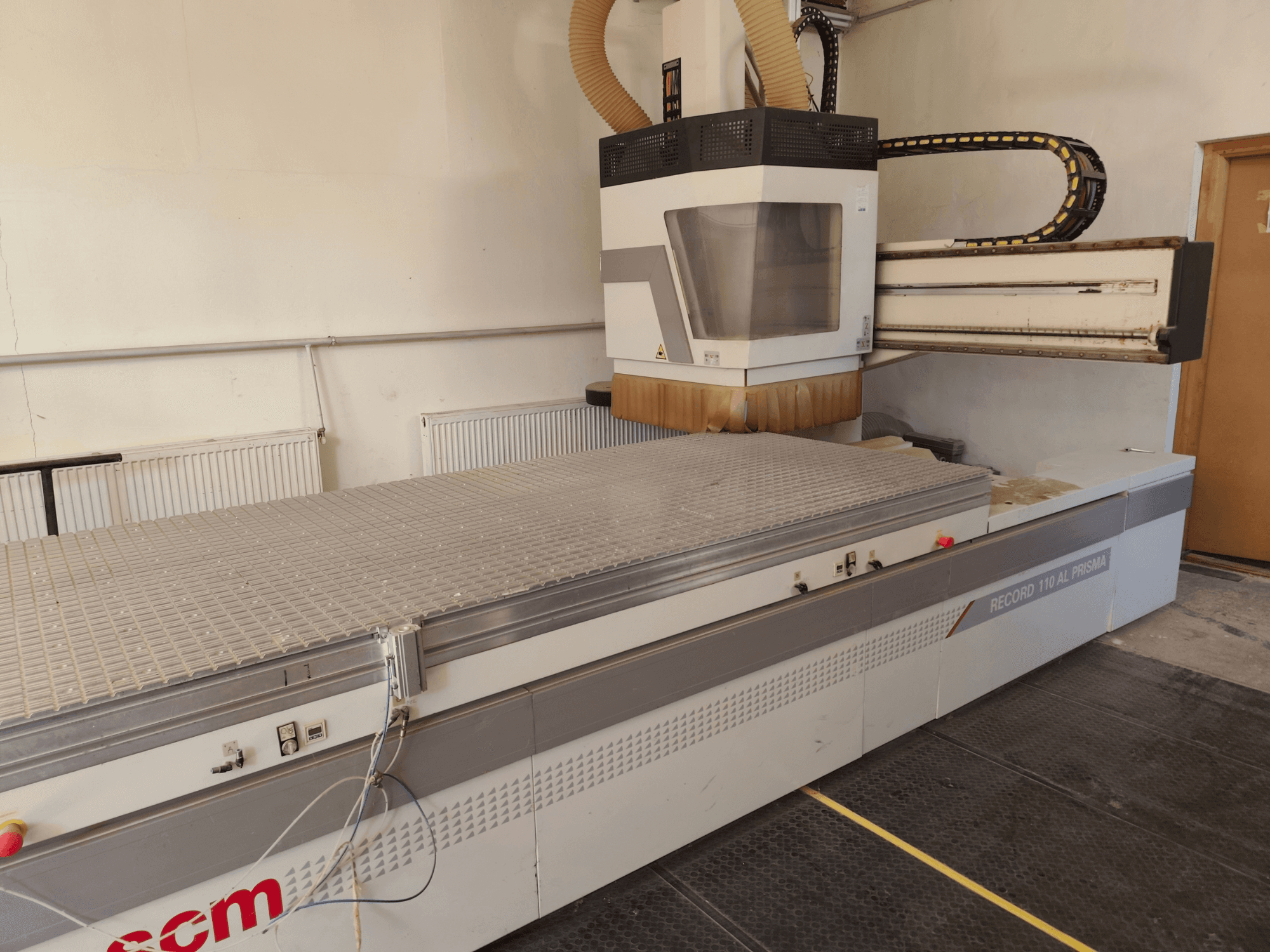 Centro de maquinagem de madeira CNC SCM Record 110AL, vista lateral que mostra a ampla mesa de trabalho e o cabeçote de fresagem.
