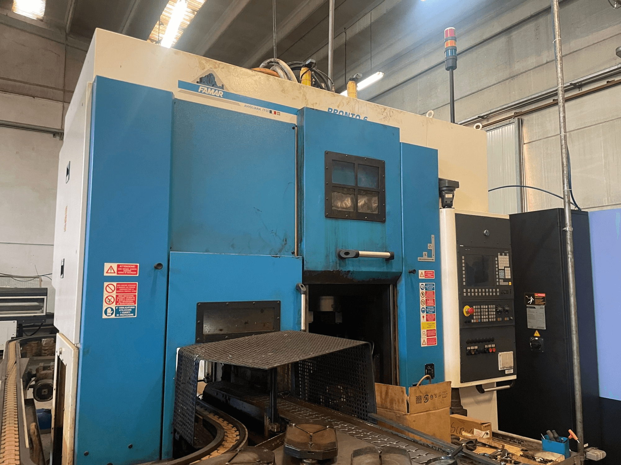 Torneiro vertical Famar Pronto 6 numa oficina, vista lateral, mostrando o painel de controlo, caraterísticas operacionais e etiquetas de segurança.